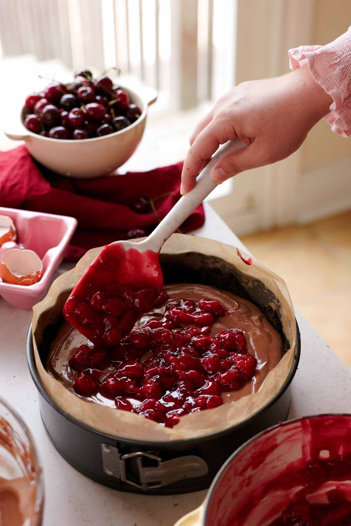 layering cherry sauce into center of cheesecake