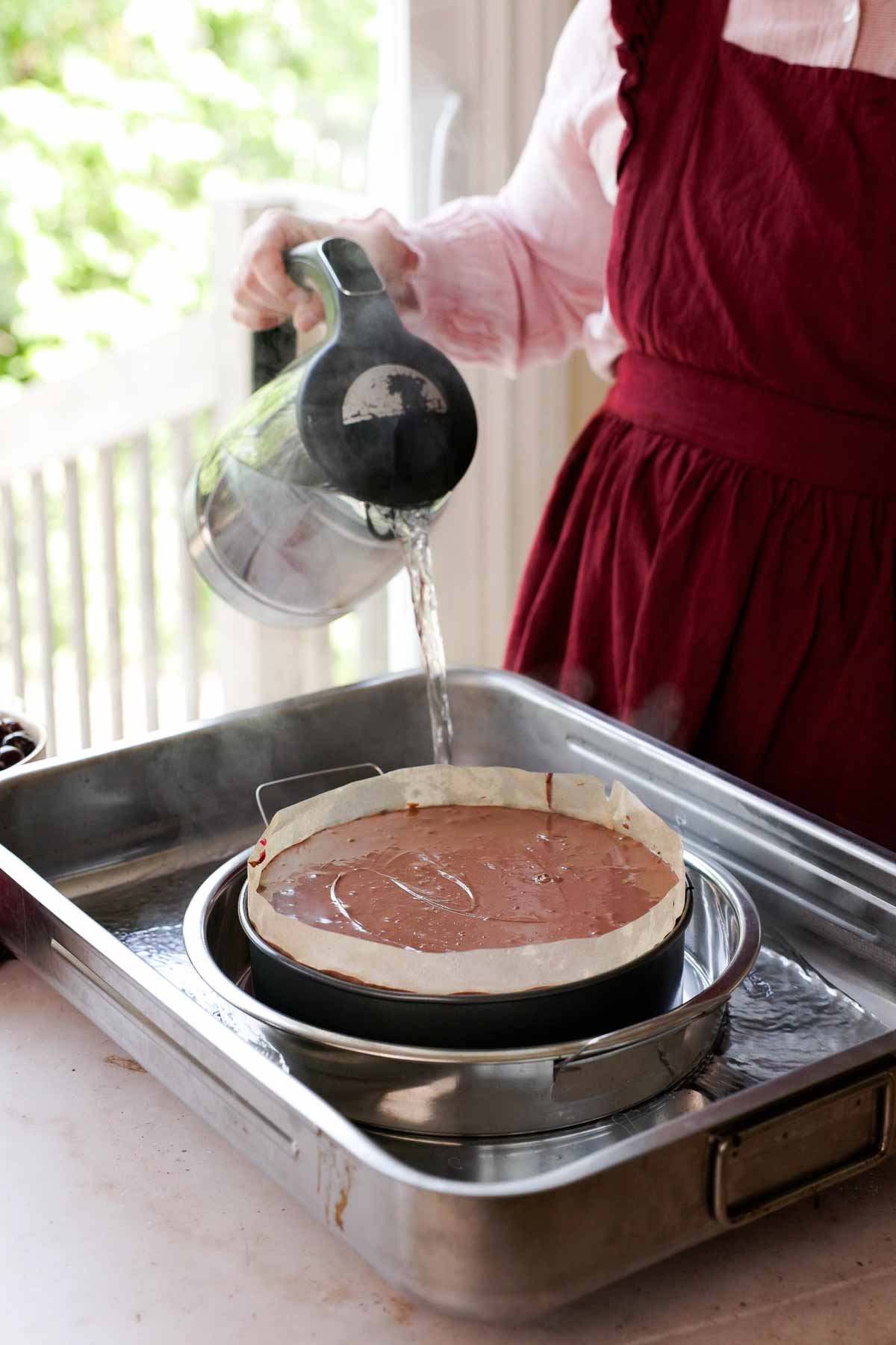 pouring boiling water into double bath for cheesecake