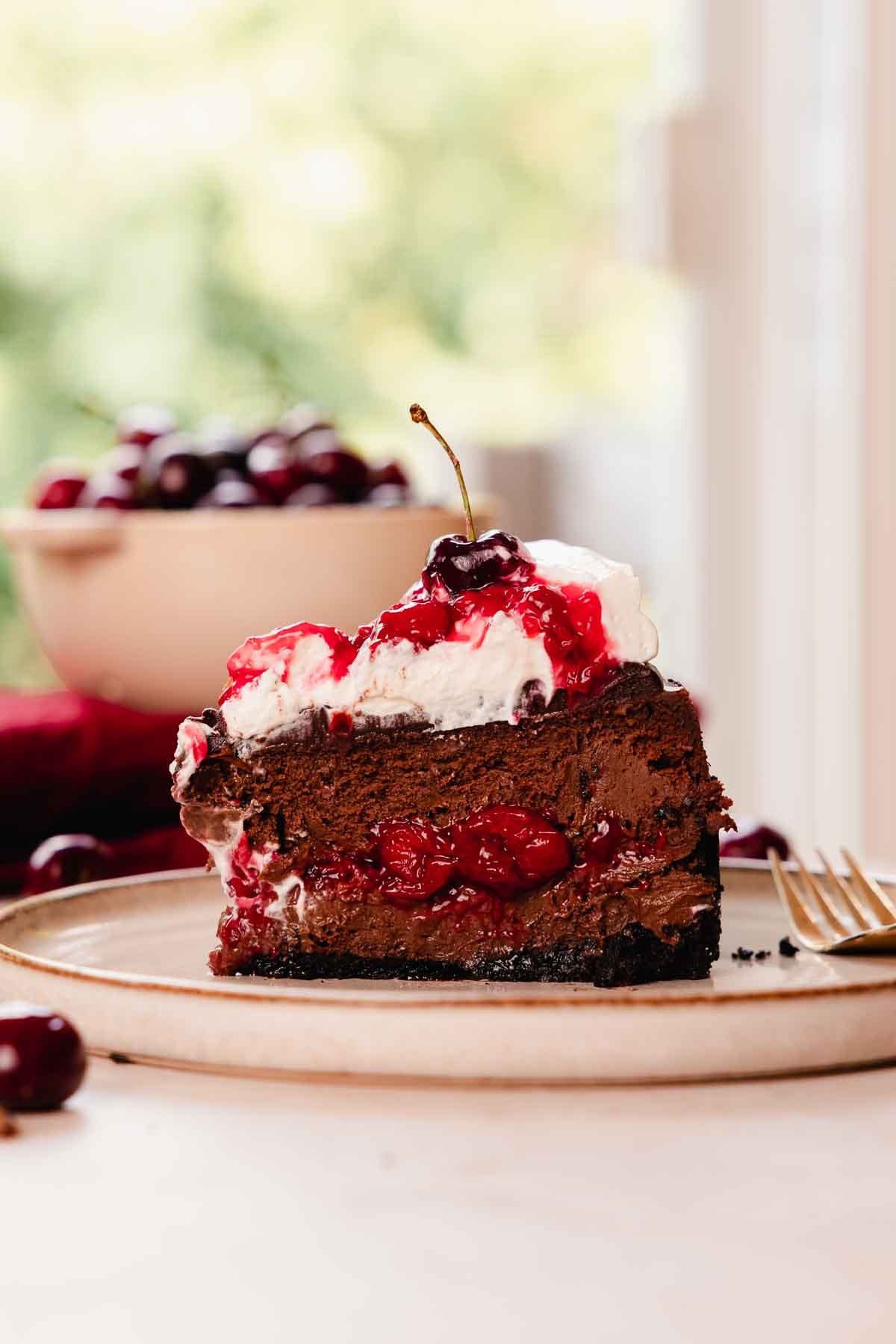slice of black forest cheesecake on plate with a fork