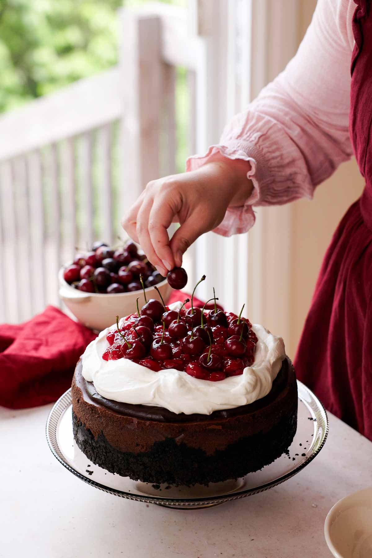 adding fresh cherries onto black forest cheesecake