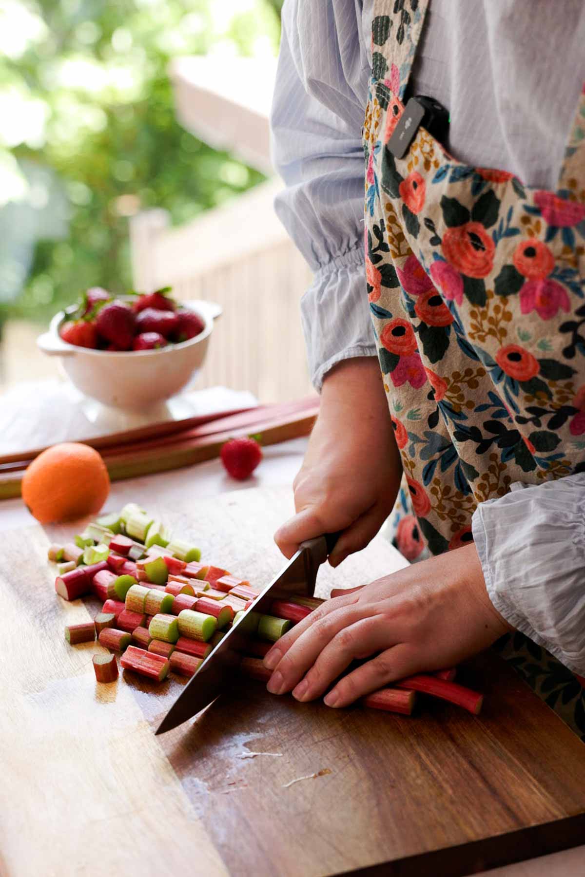 chopping rhubarb into chunks on cutting board