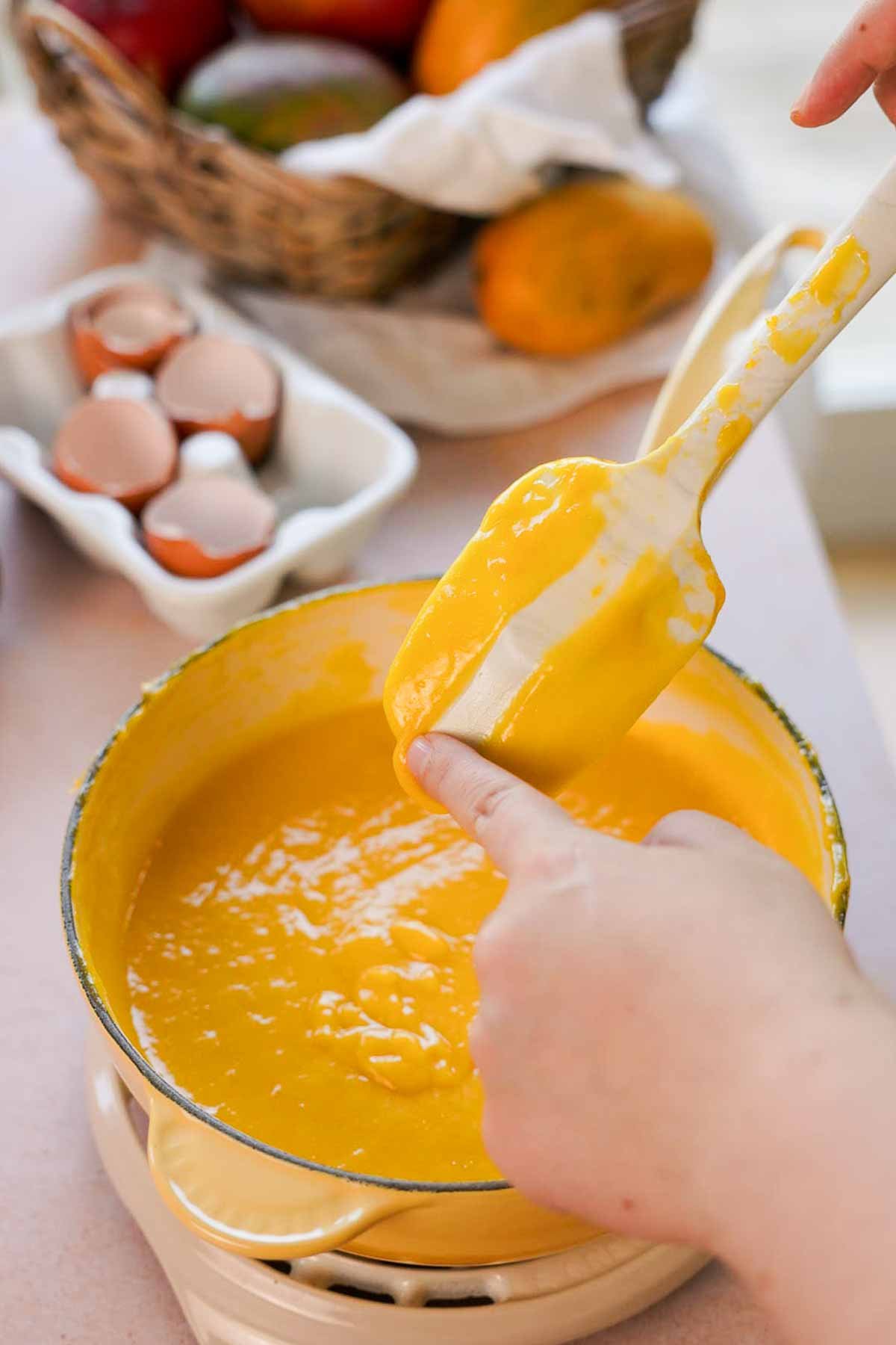 cooked mango curd on the back of a spoon