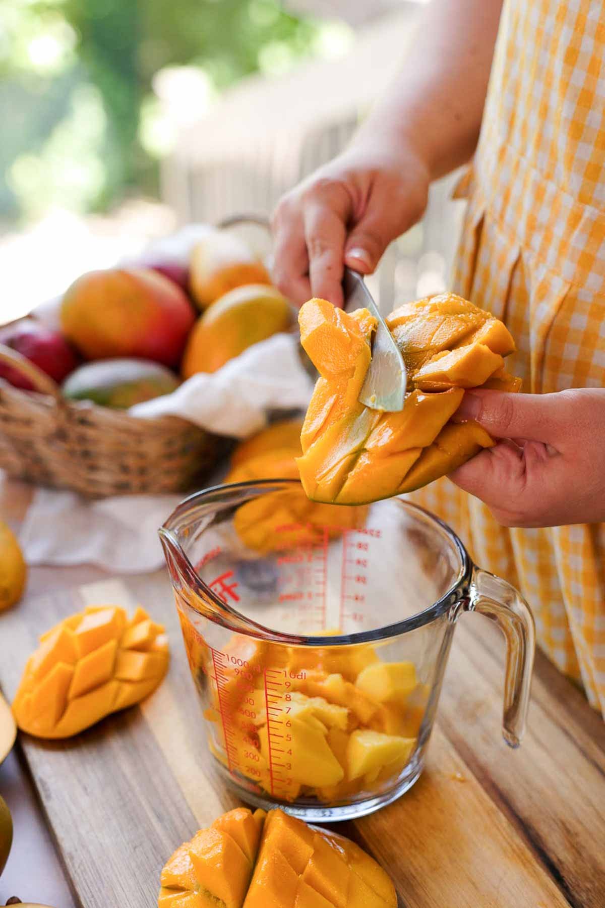 slicing mango into measuring cup