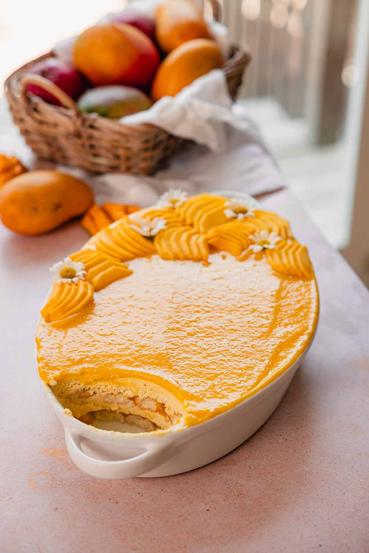 mango tiramisu in white tray with mango curd and fresh mango slices