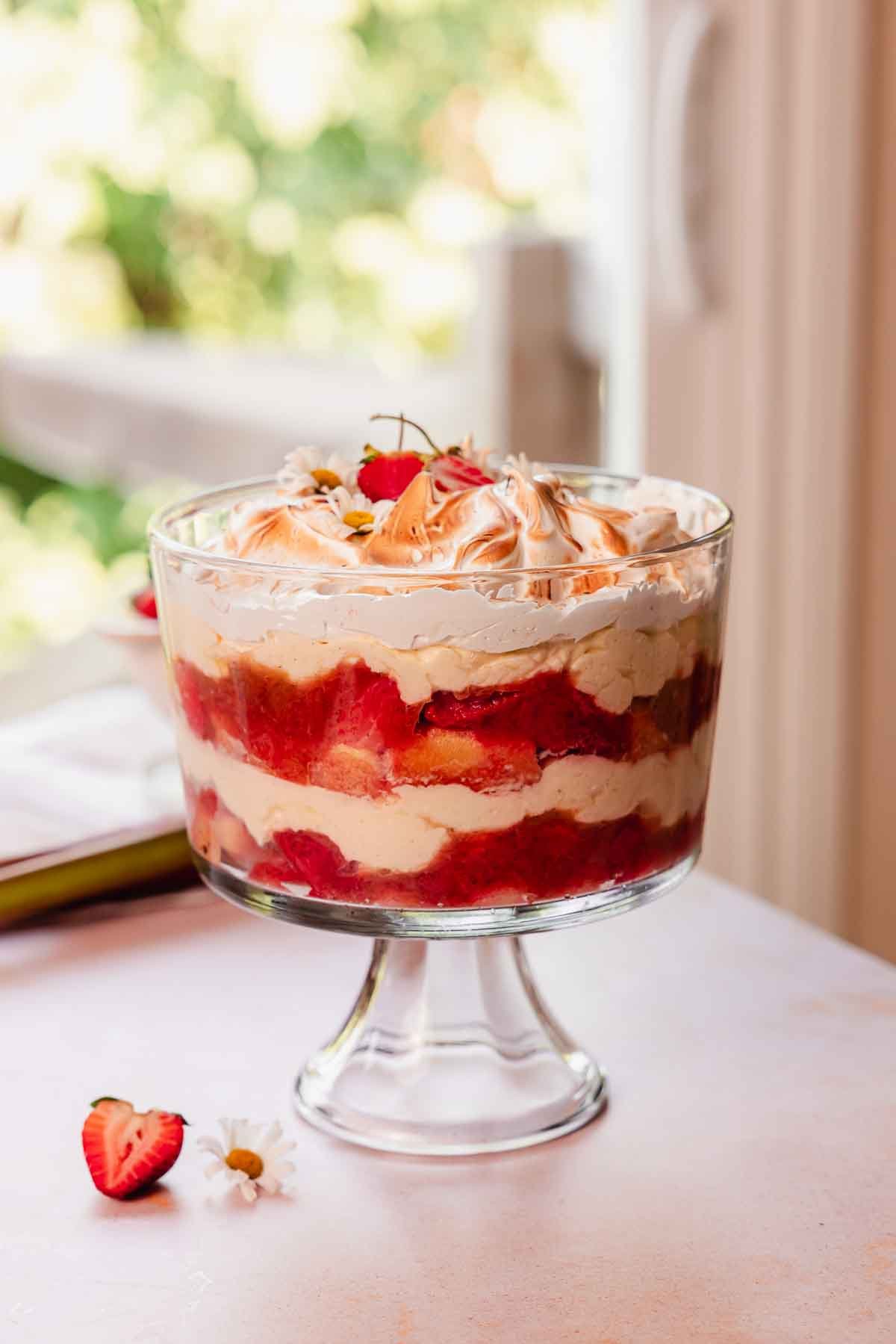rhubarb trifle with custard layered in glass trifle container with toasted meringue on top