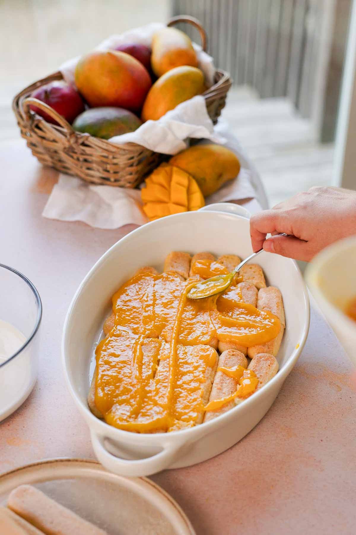 spreading mango puree on ladyfingers
