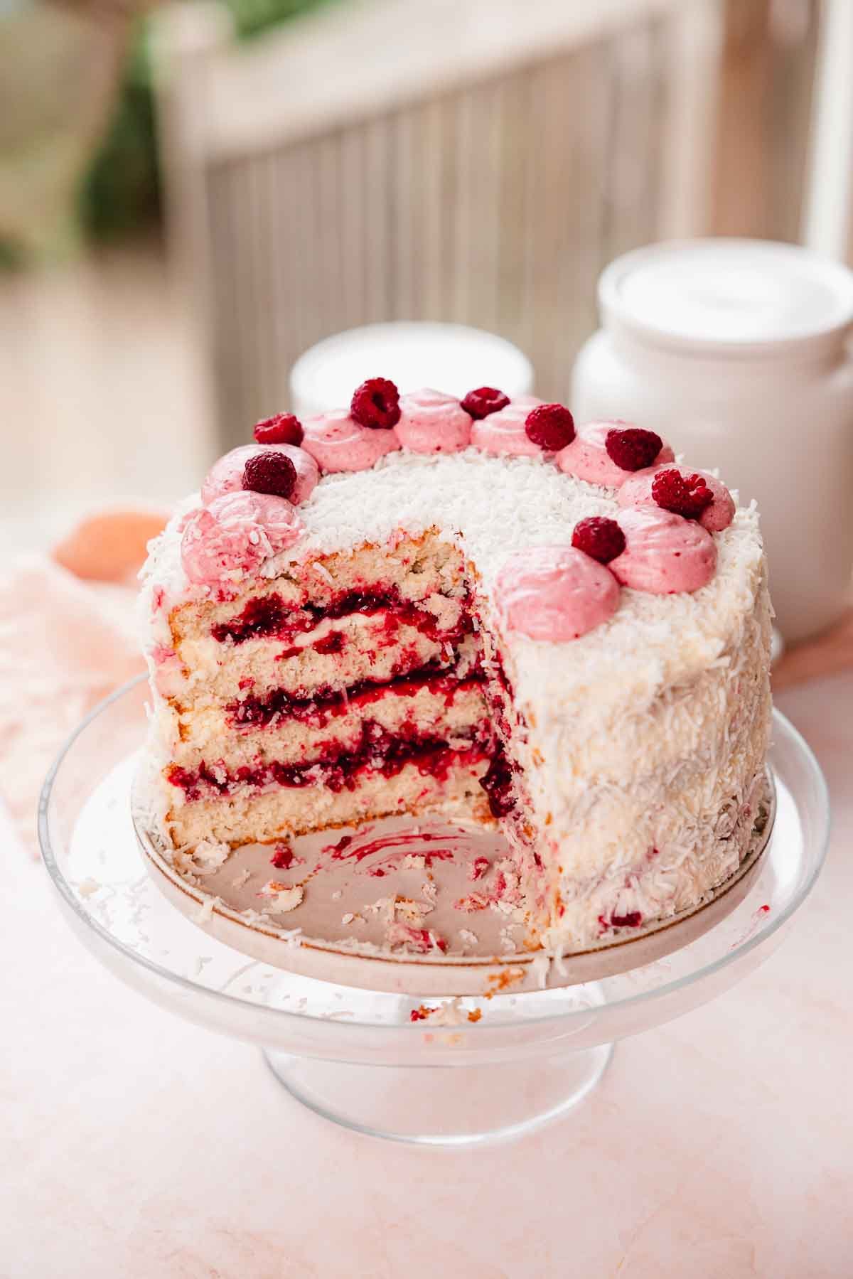 coconut cake with raspberry filling and raspberries on top