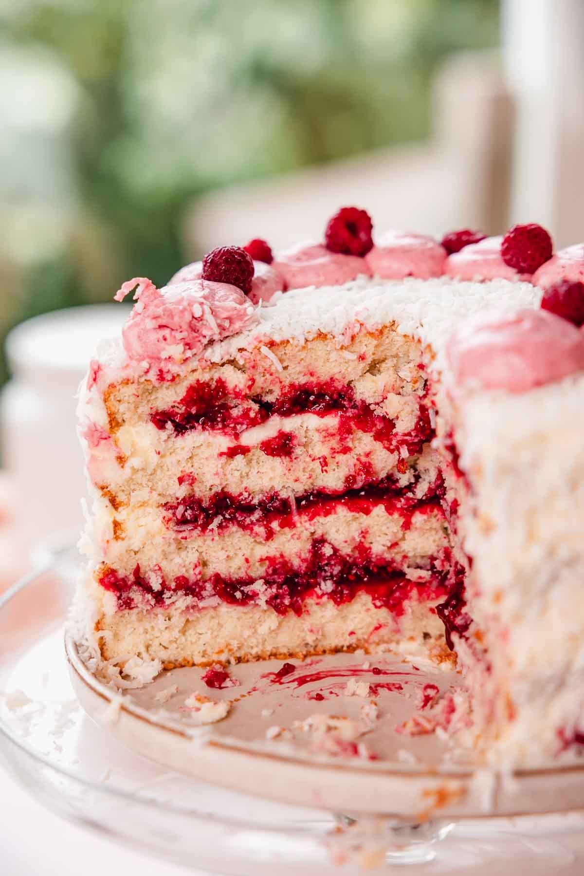 coconut layer cake with raspberry filling on cake stand