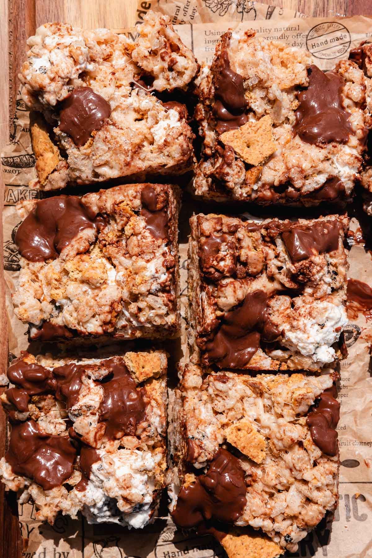 squares pf smores rice krispies with pieces of melted chocolate on top on parchment paper