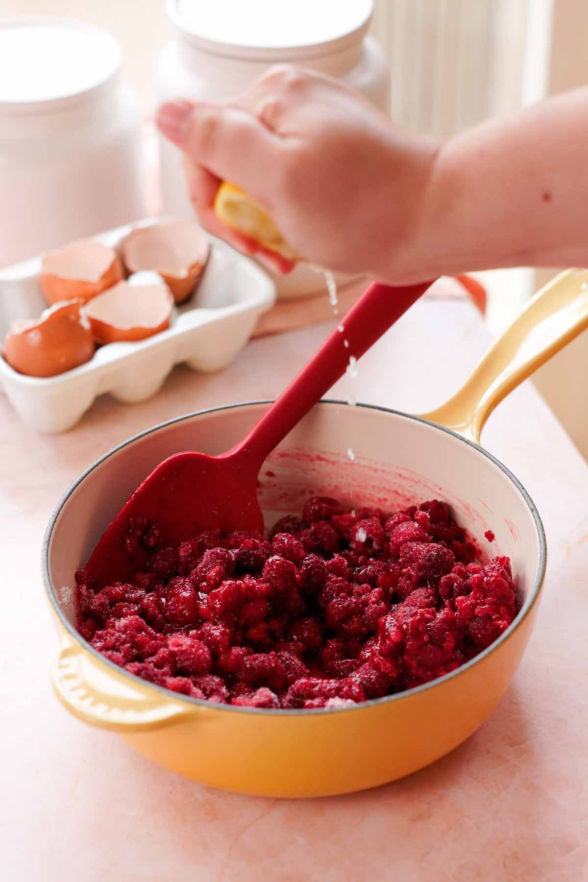 squeezing lemons into frozen raspberry cake filling