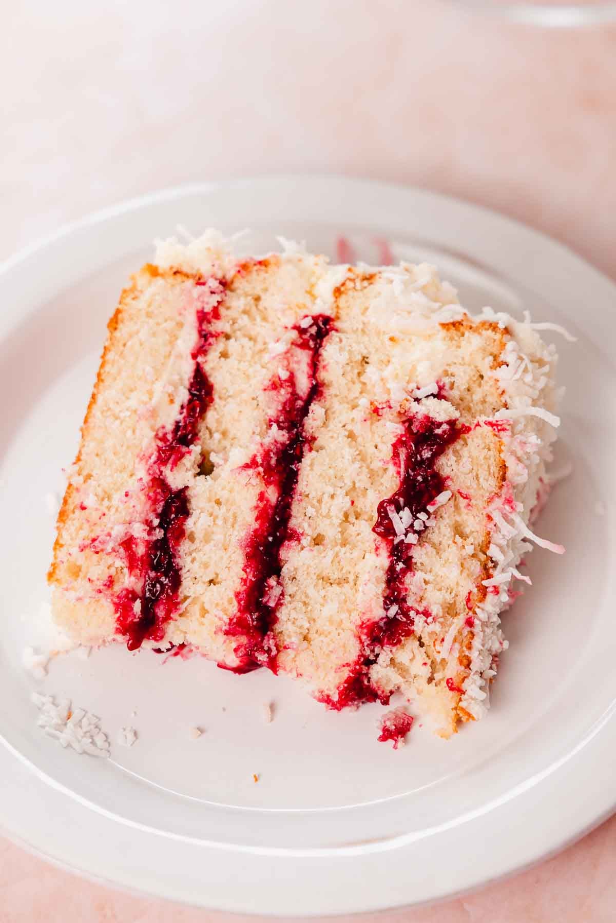 slice of coconut and raspberry cake on a plate