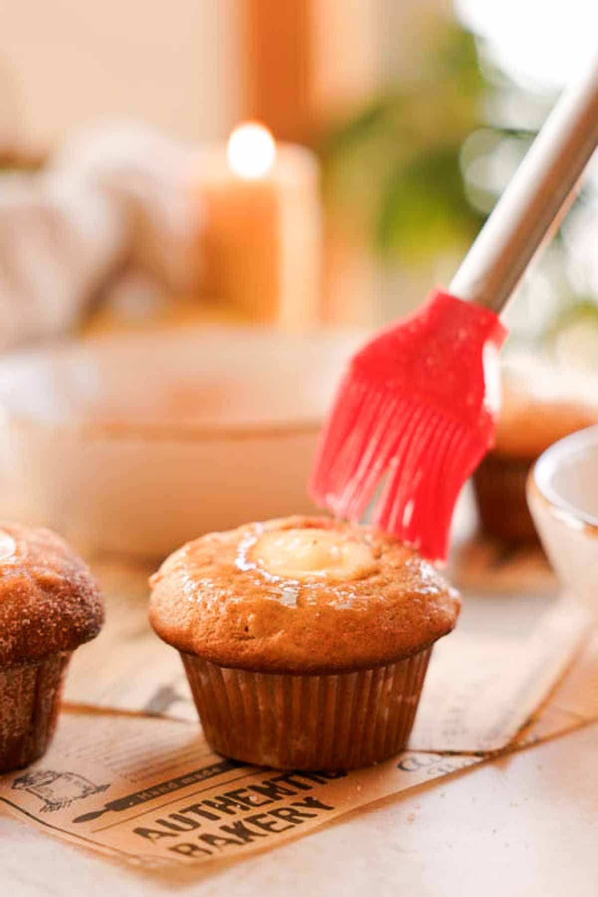 brushing muffins with apple cider and butter