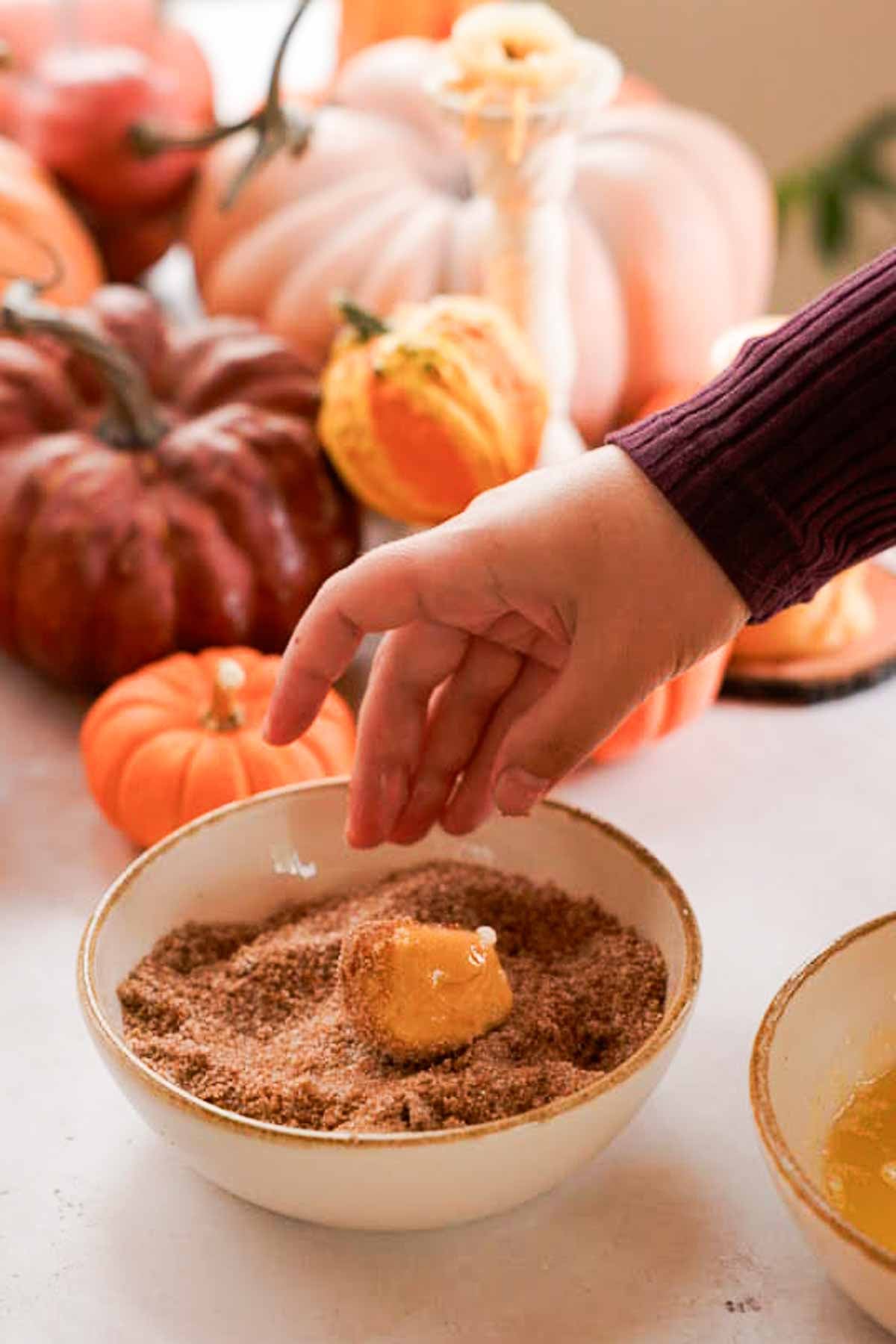rolling buttered monkey dough balls in pumpkin spice and sugar