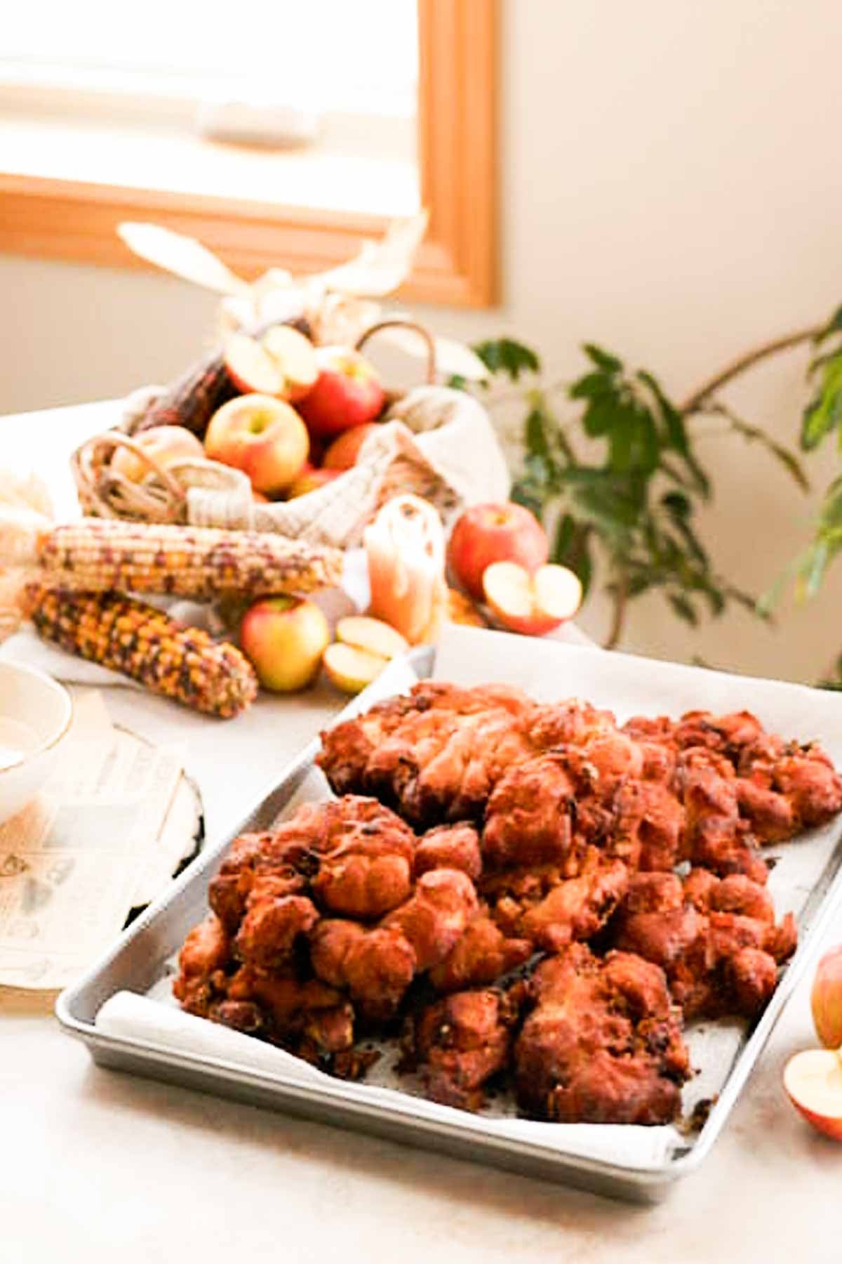 tray of apple fritters draining on paper towel