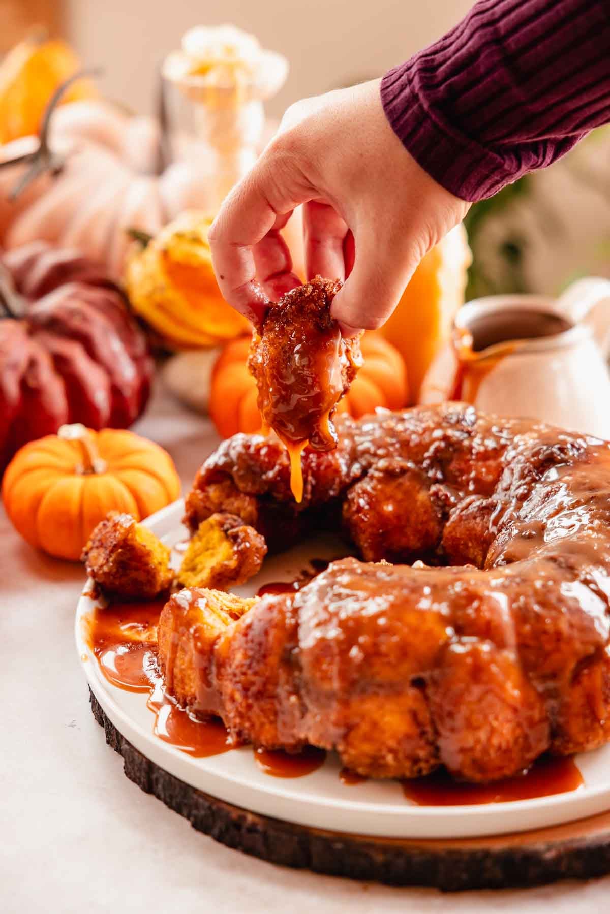 pulling piece of caramel coated pumpkin monkey bread up