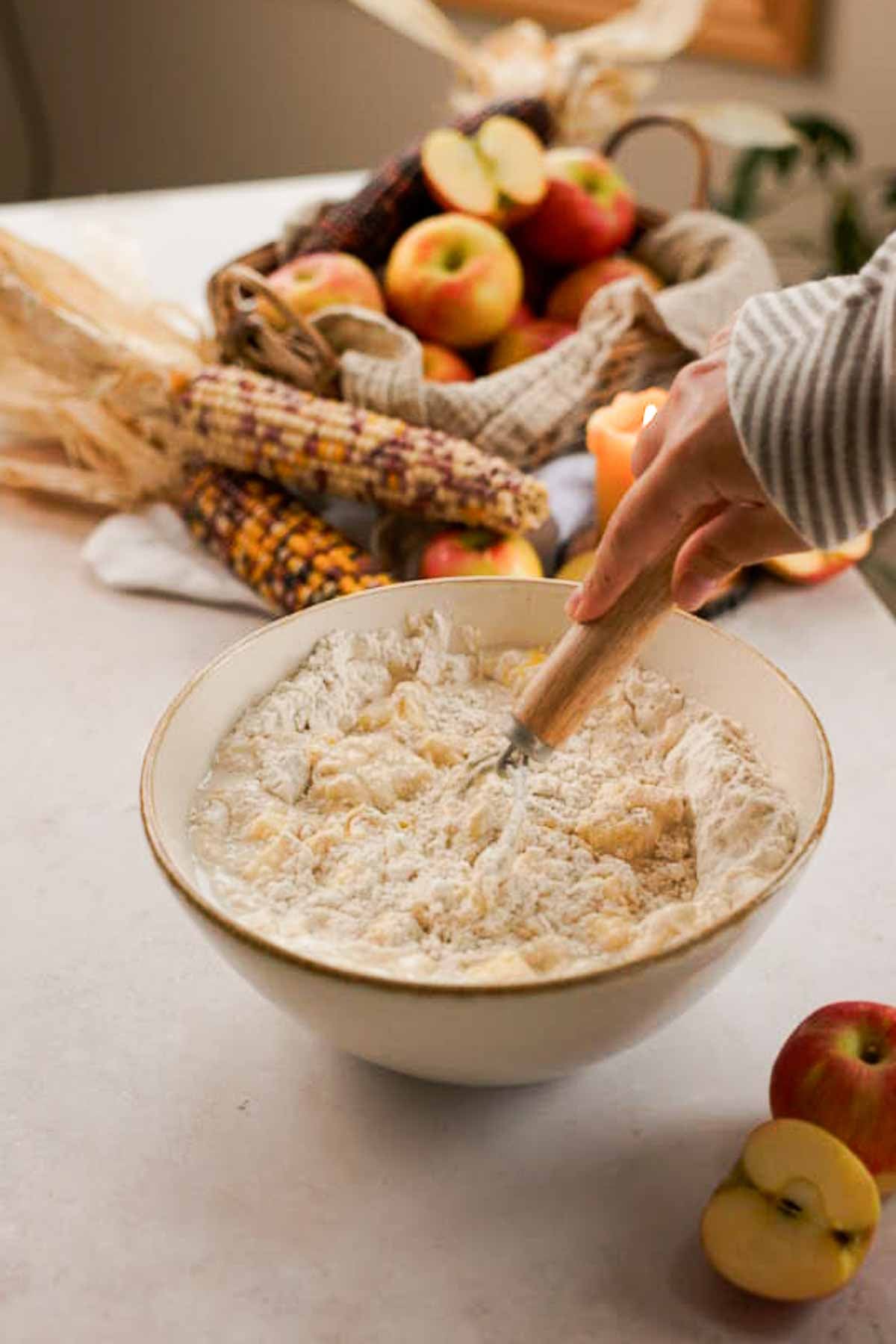 stirring no knead fritter dough together with a danish whisk in a large bowl