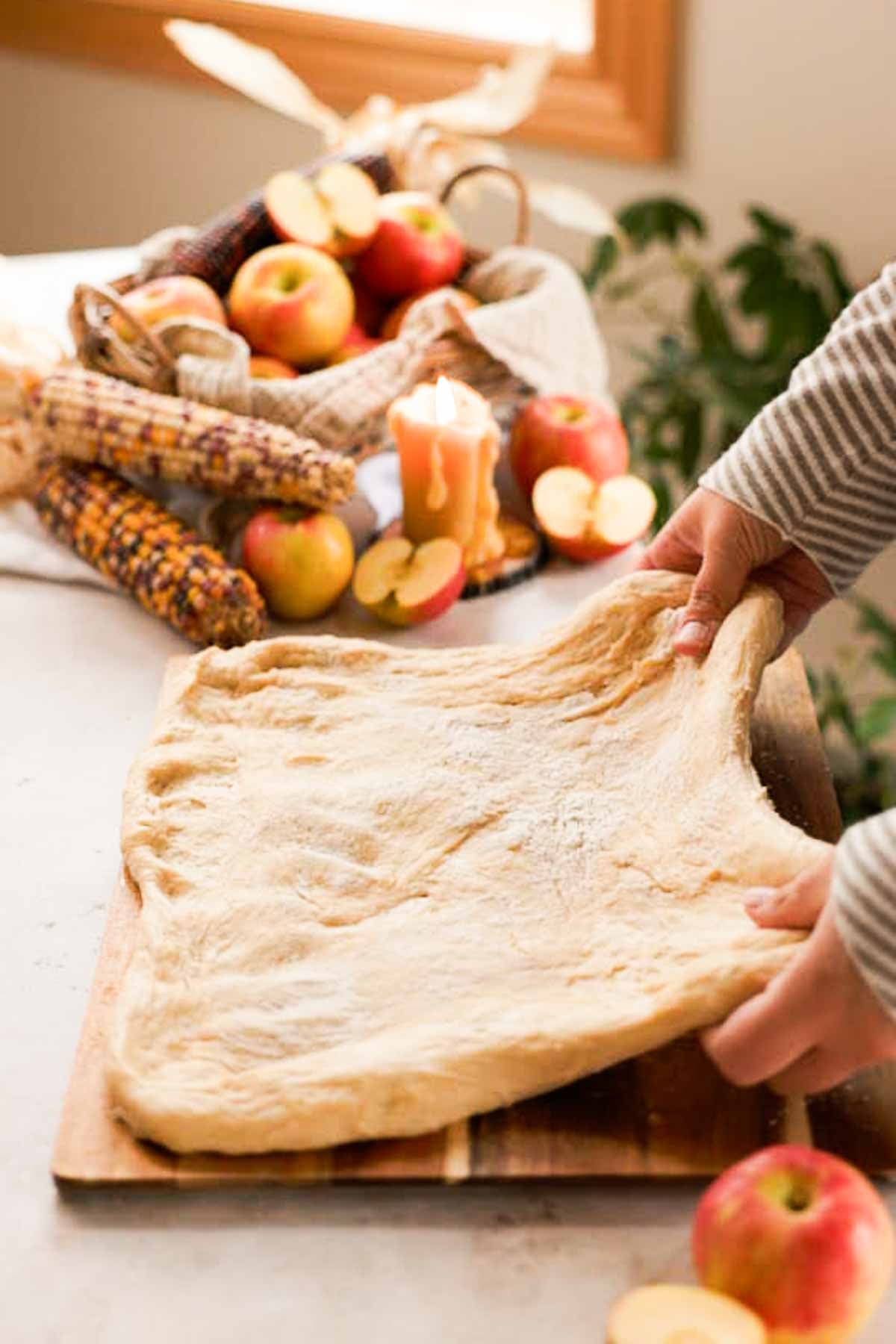 stretching donut dough into a rectangle on a cutting board