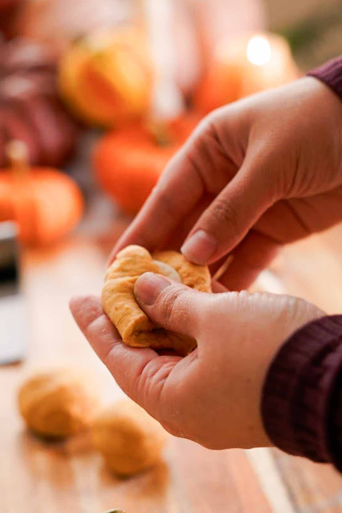 stuffing frozen cream cheese filling into pumpkin monkey bread dough