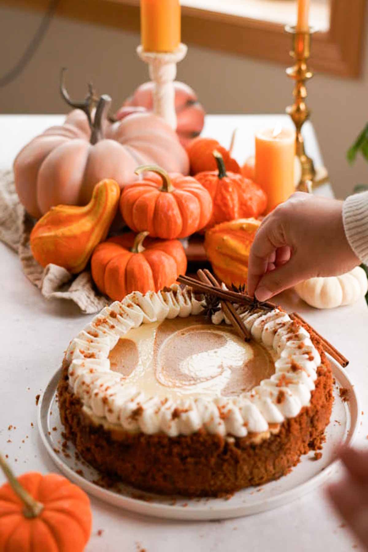 decorating pumpkin pie cheesecake with cinnamon sticks and anise seed pods