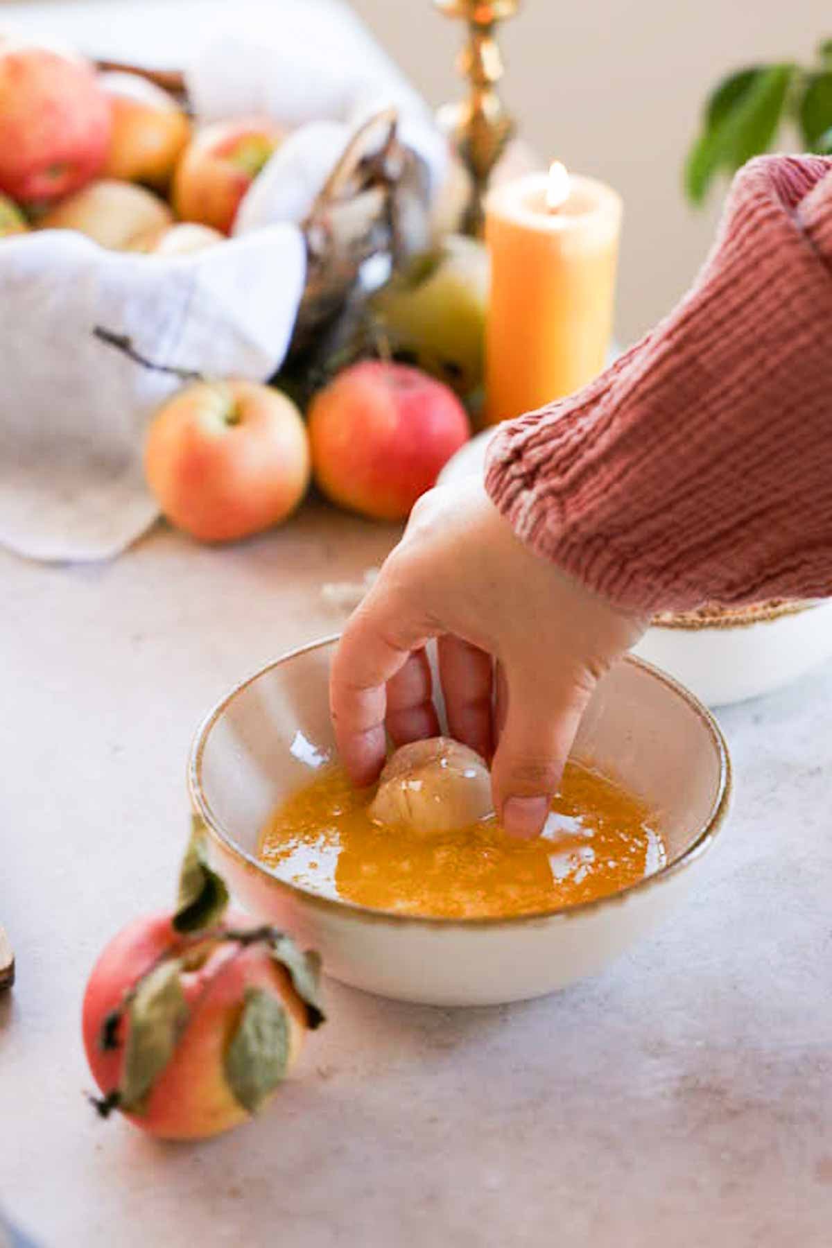 dipping caramel stuffed monkey bread ball into melted sugar