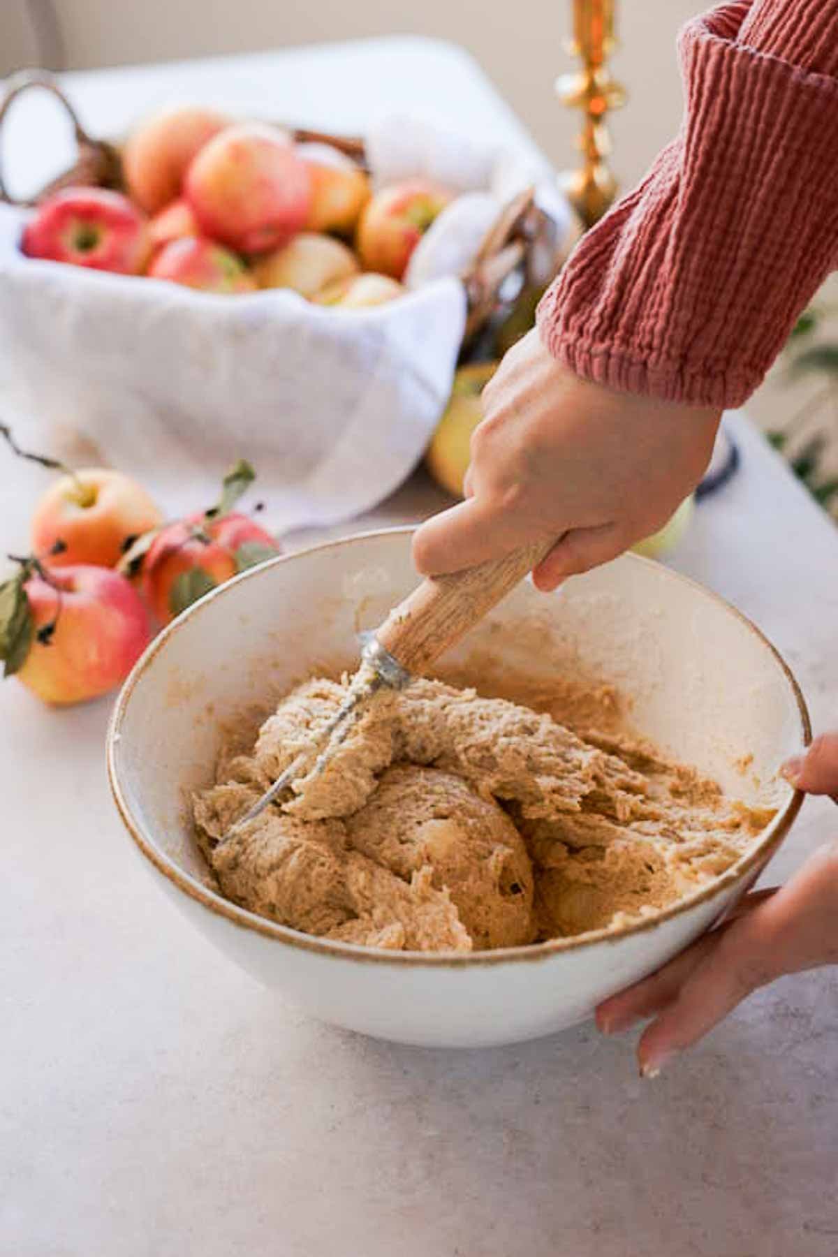 mixing monkey bread dough in a large bowl together