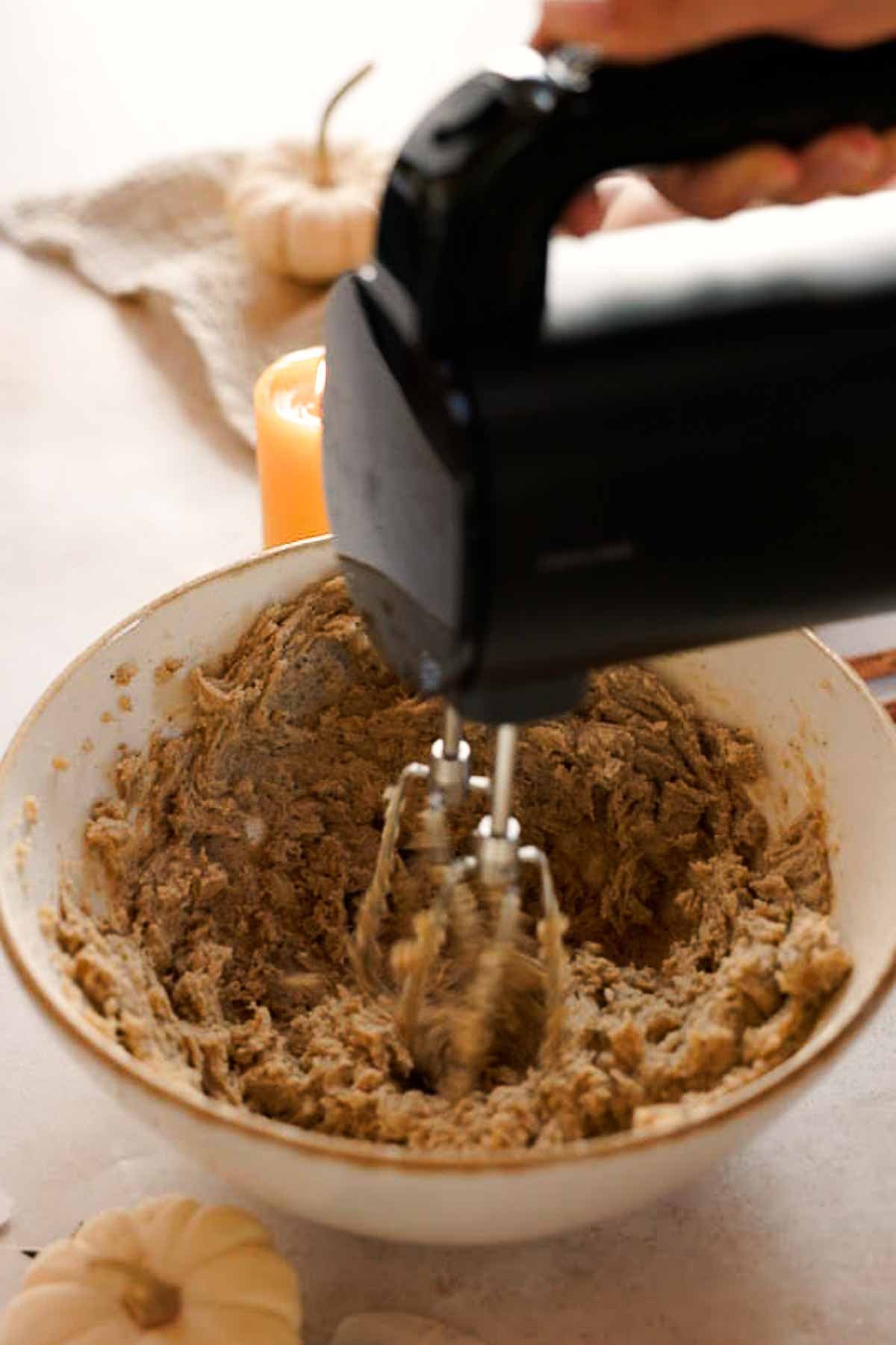 mixing butter, sugar, and chai teabags with an electric mixer