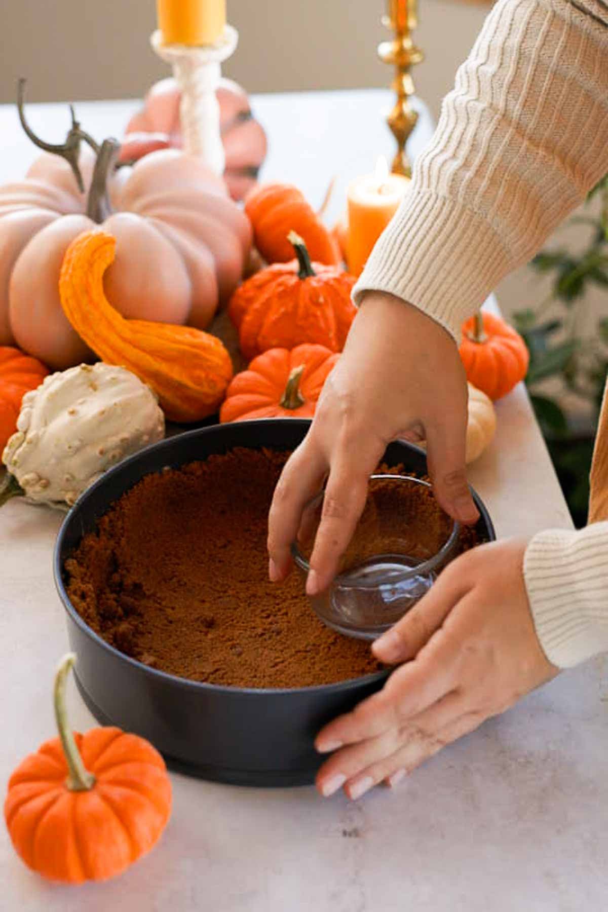 pressing biscoff crumbs into a springform pan
