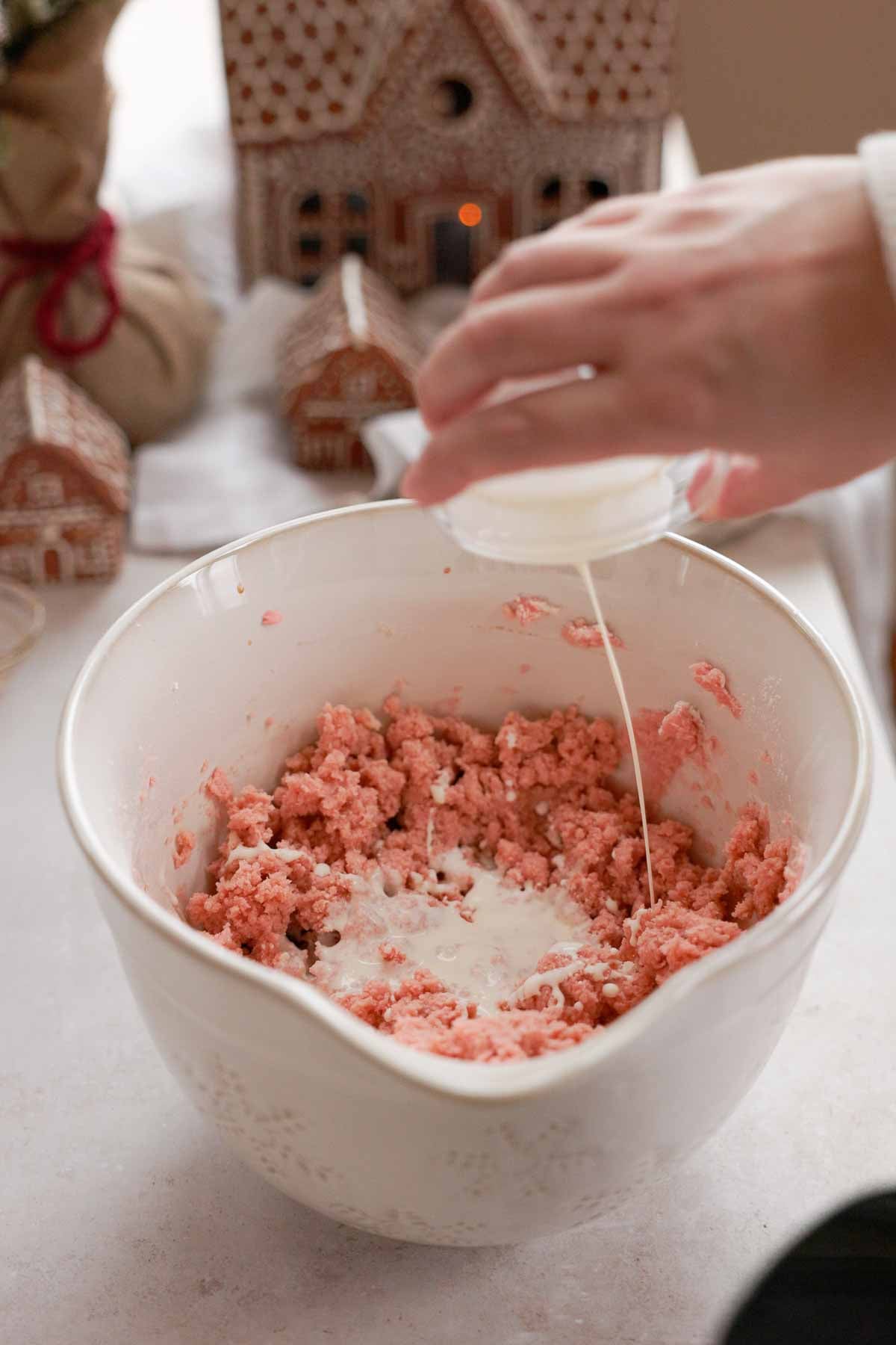 adding cream to pink butter cookie dough