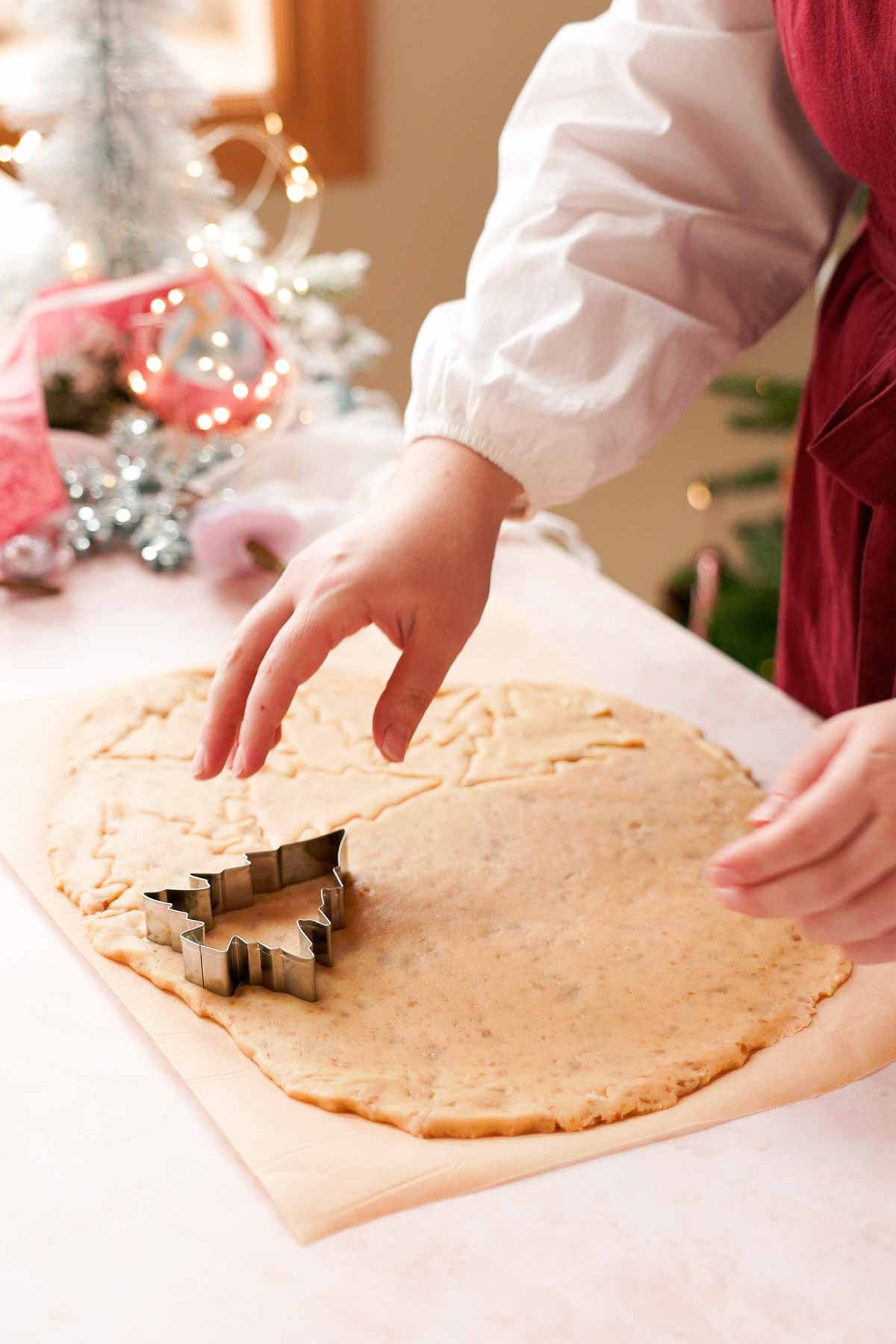 cutting out christmas trees from caramel sugar cookie dough