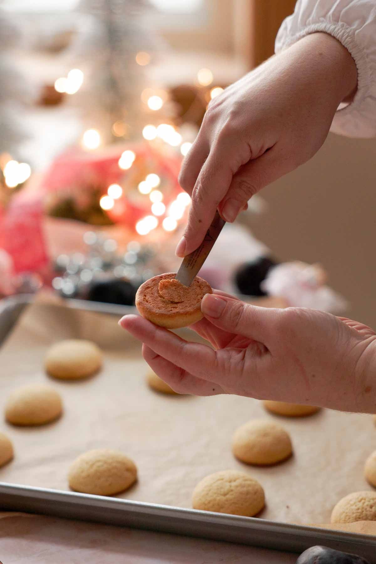 cutting out centers of plum cookies with a small knife