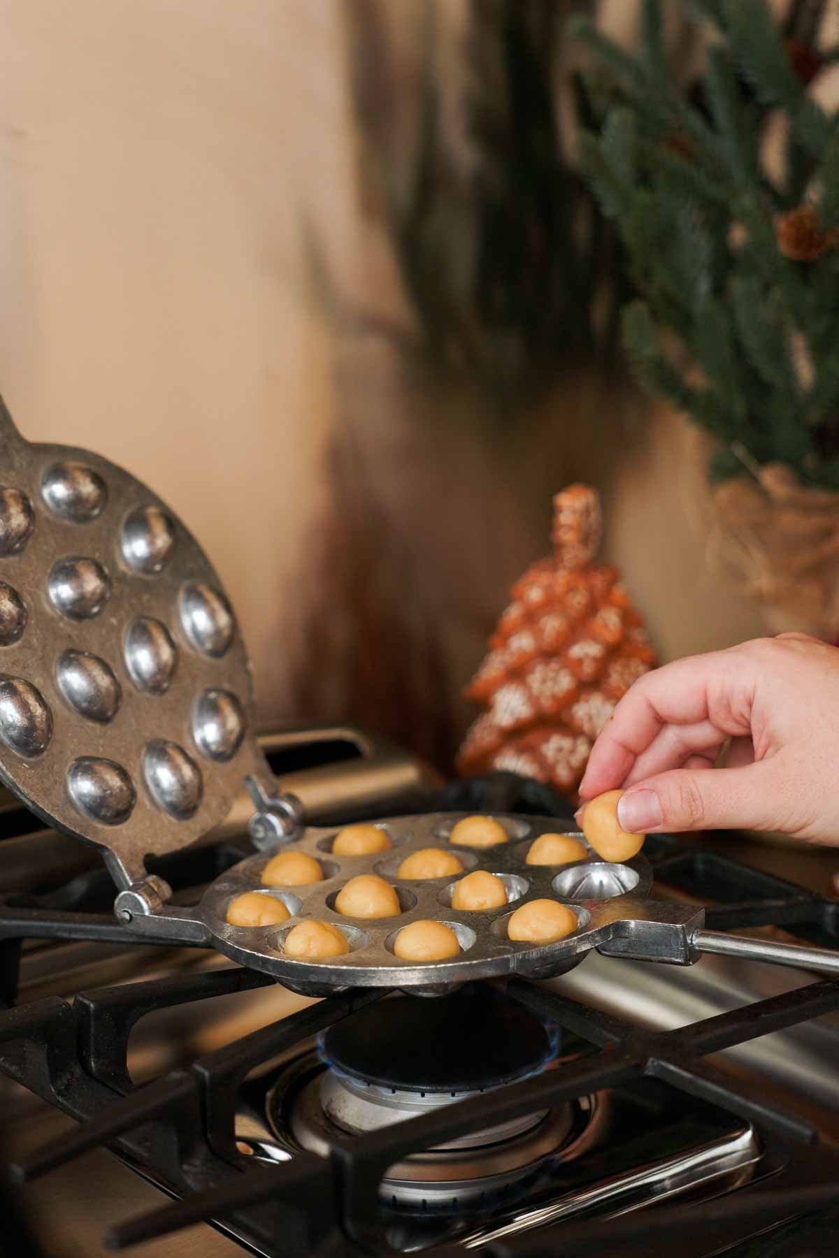 placing balls of cookie dough into oreshki walnut cookie mold