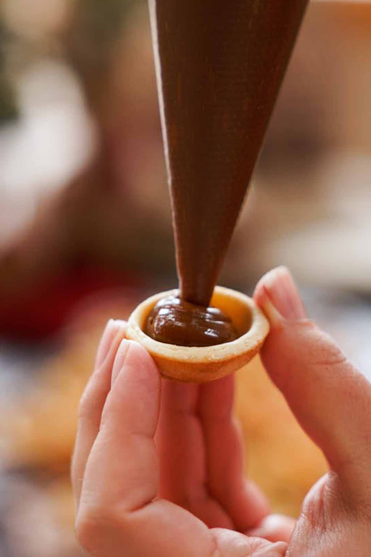 filling walnut cookies with dulce de leche