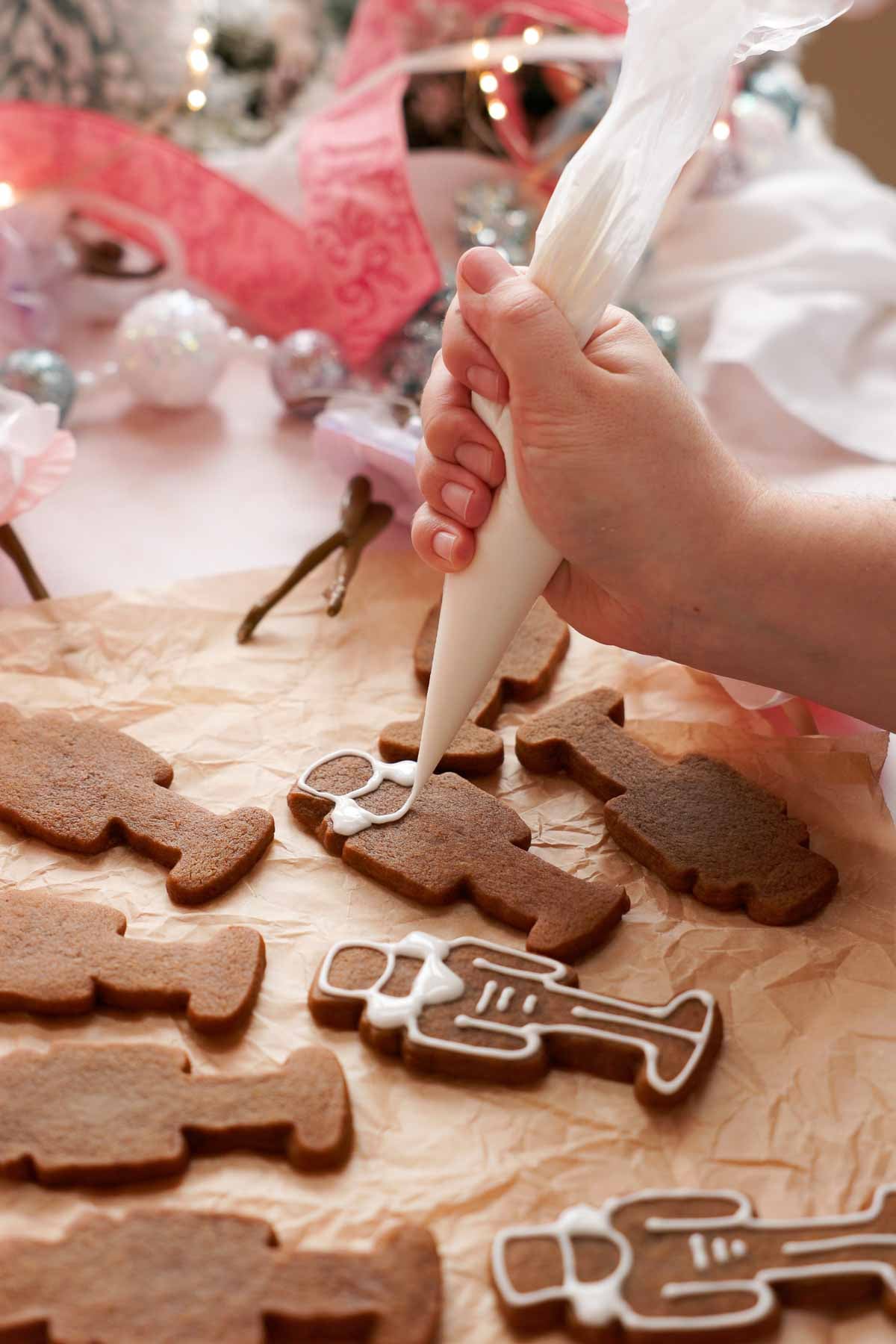 piping outlines onto gingerbread nutcracker cookies