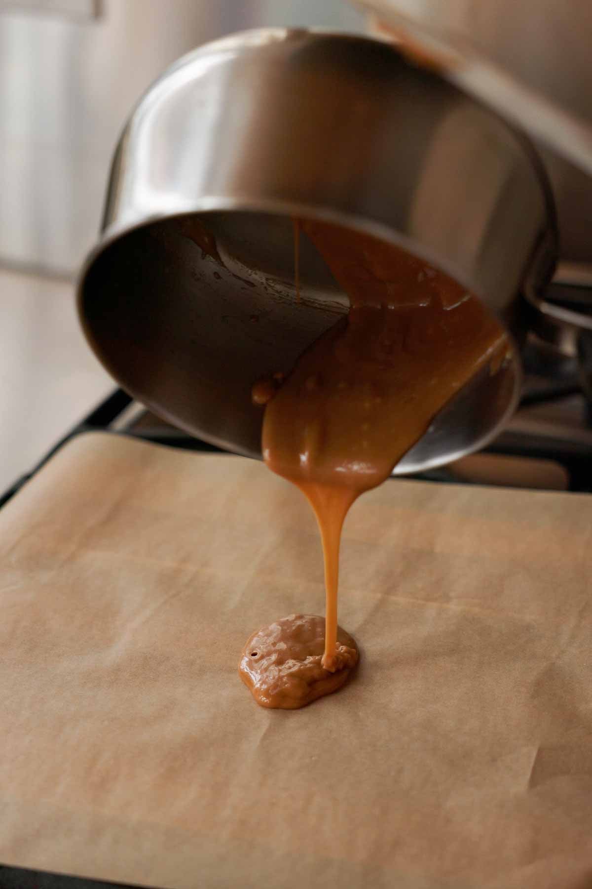 pouring hot toffee onto parchment paper to set