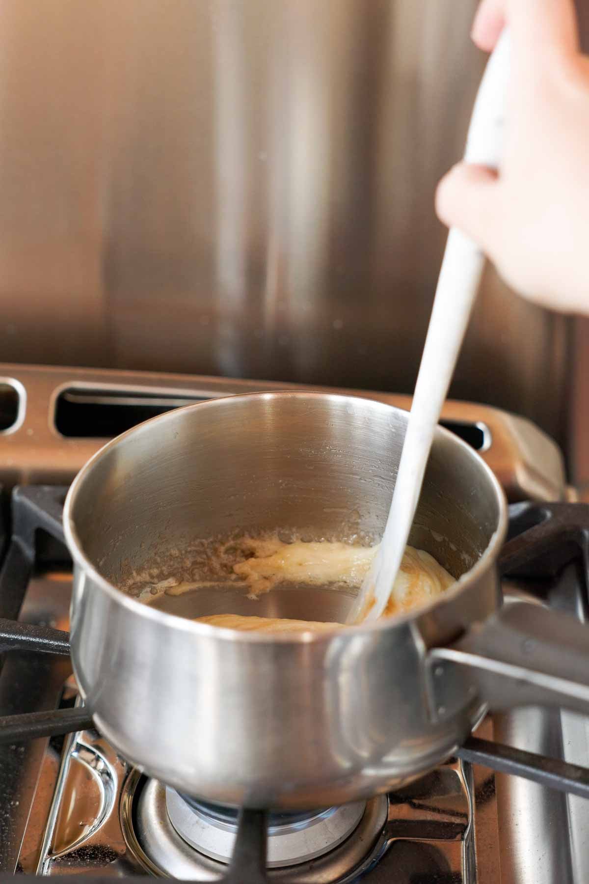 slowly moving toffee around in the saucepan with silicone spatula