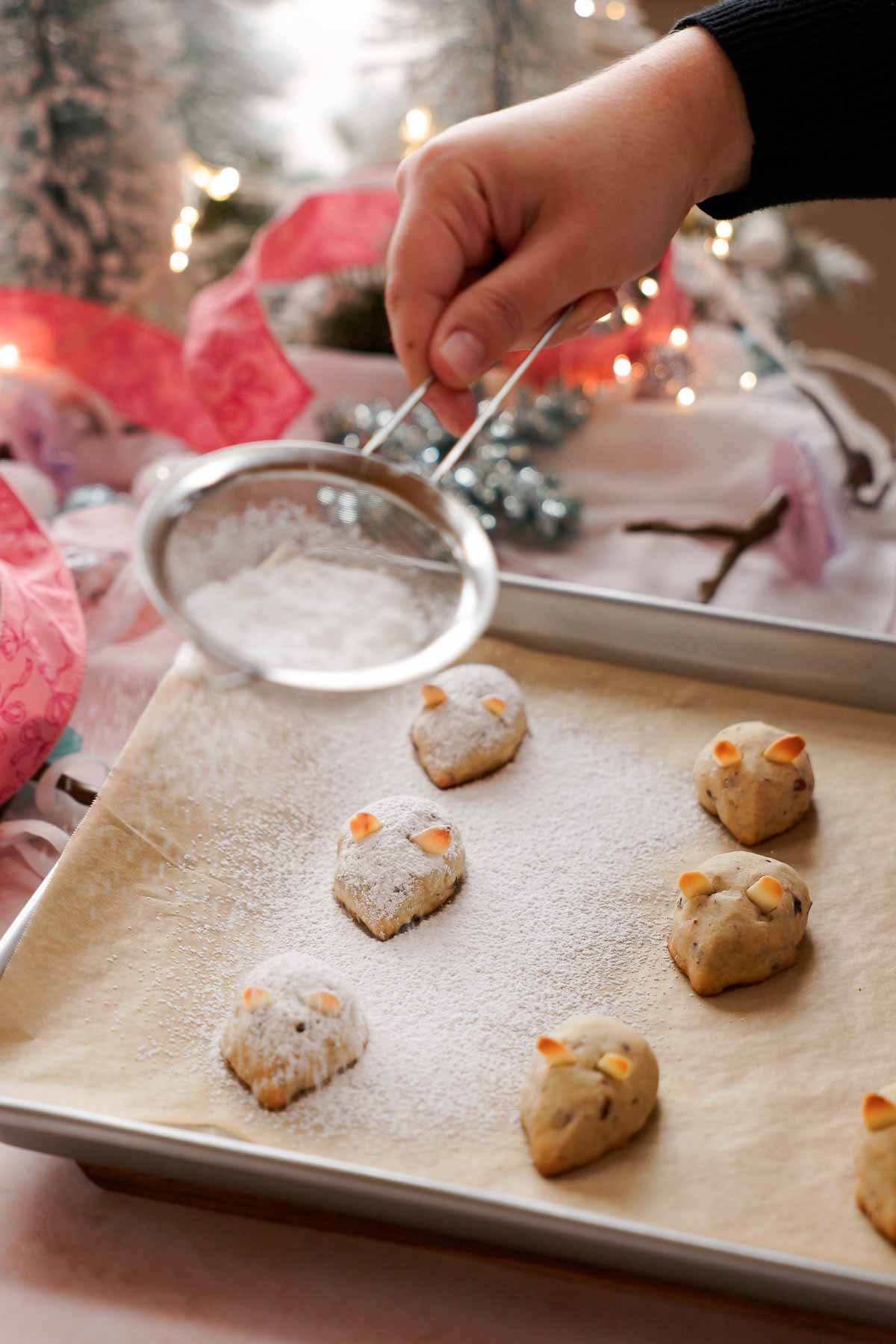 dusting baked mouse cookies with powdered sugar