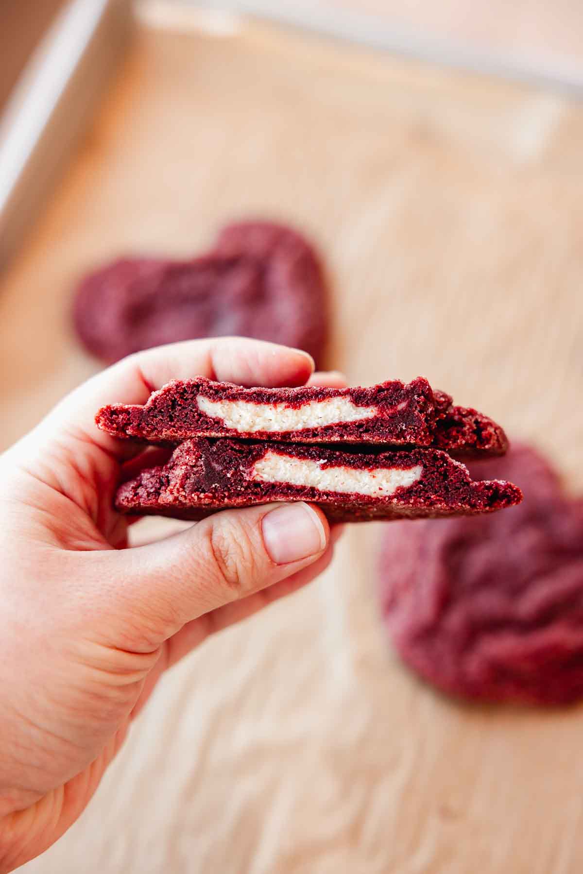 red velvet cookie cut in half to show cream cheese cheesecake filling