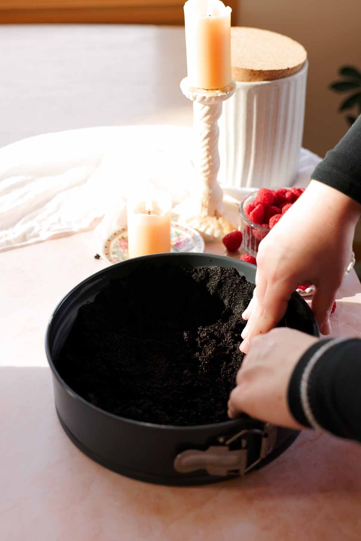 pressing oreo crumbs into springform pan