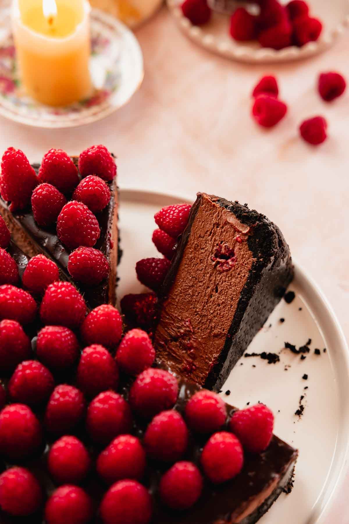 slice of chocolate raspberry no bake creamy cheesecake on cake plate