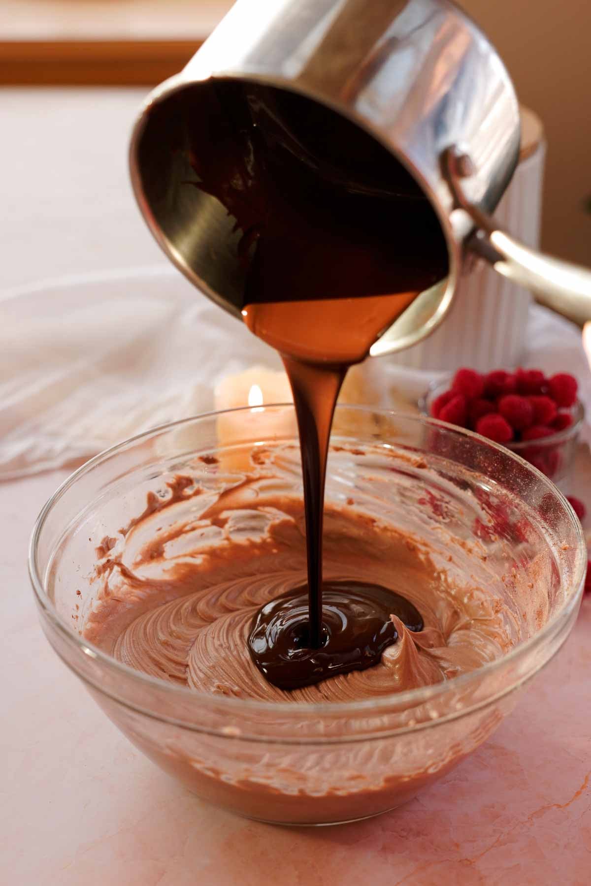 pouring melted chocolate into no bake chocolate cheesecake mixture