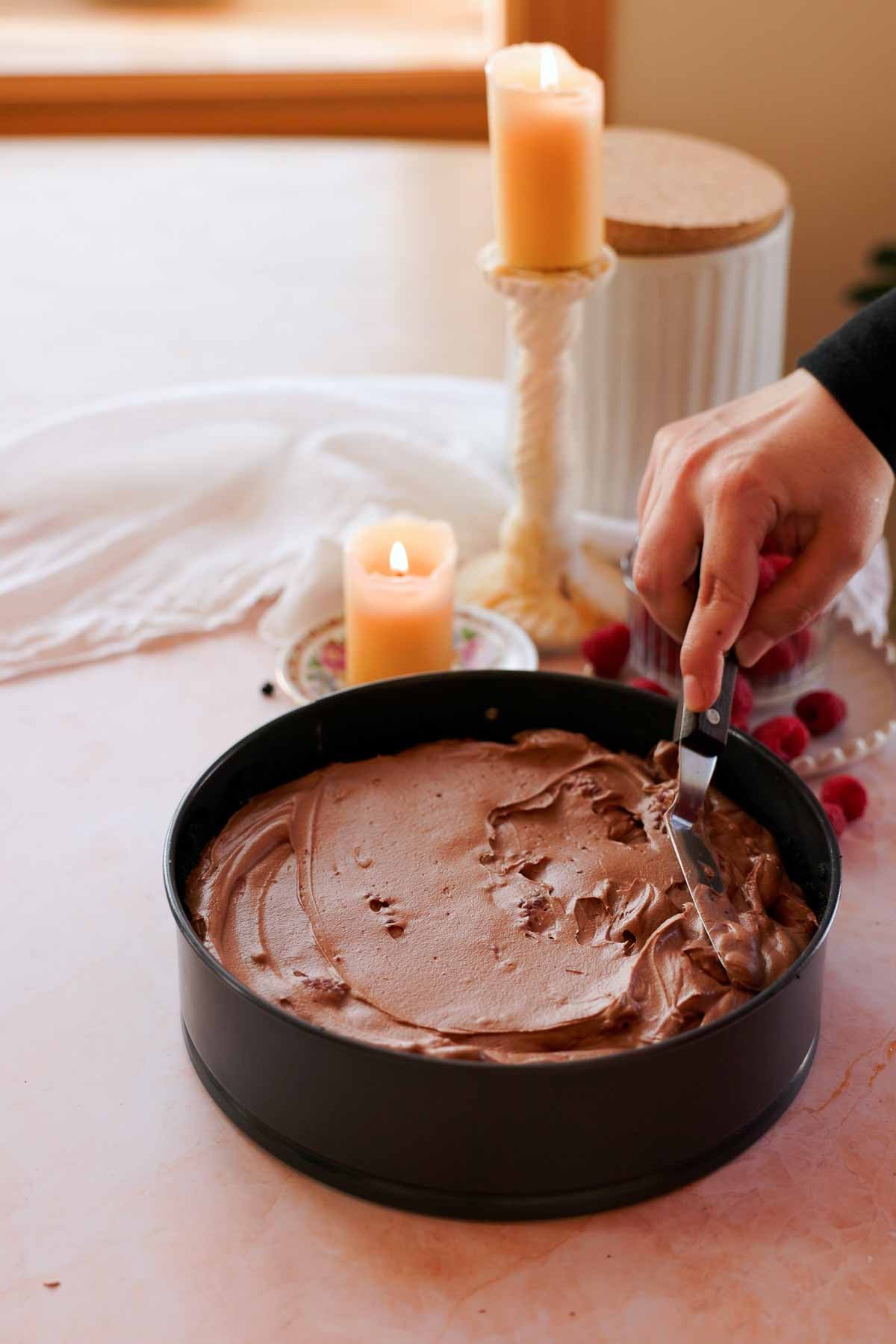 spreading chocolate raspberry cheesecake filling into springform pan