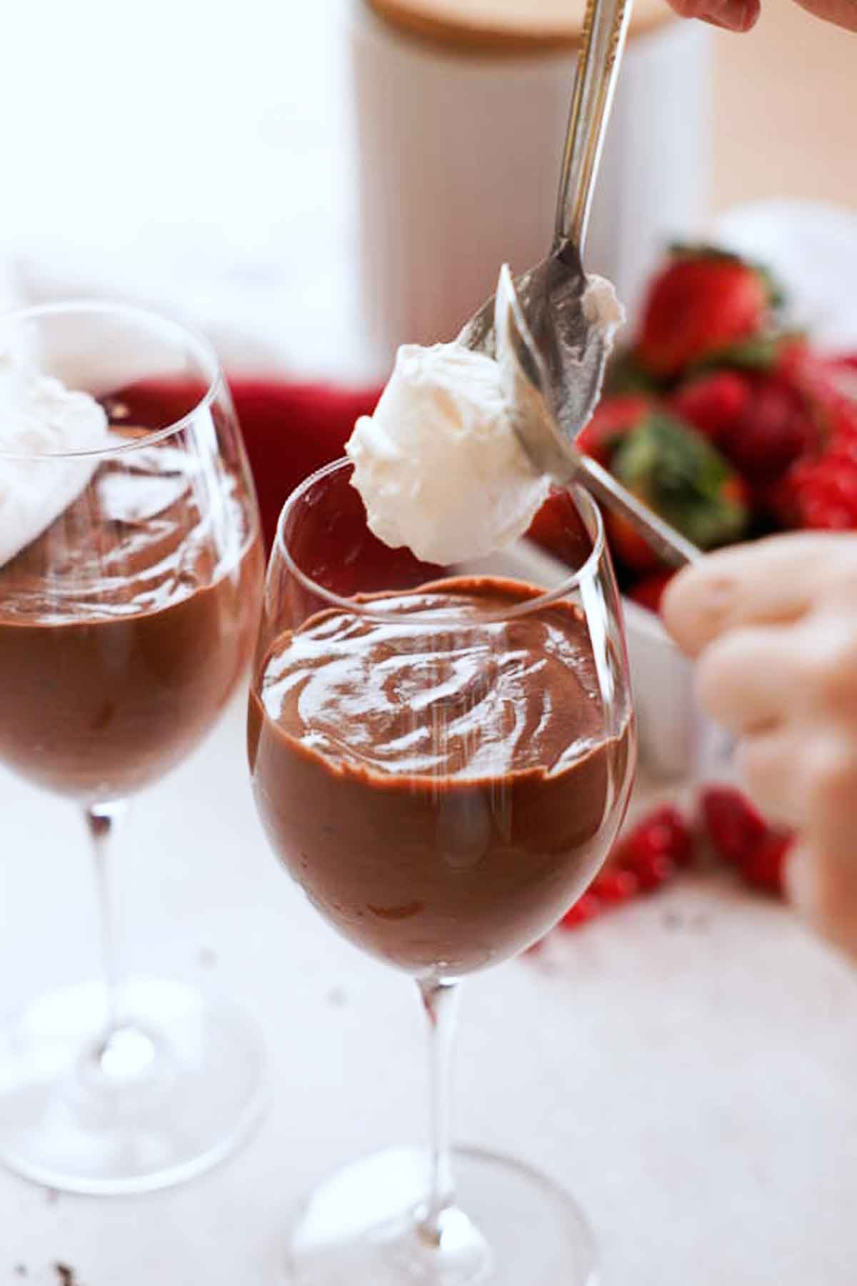 topping red wine mousse with whipped cream in wine glasses