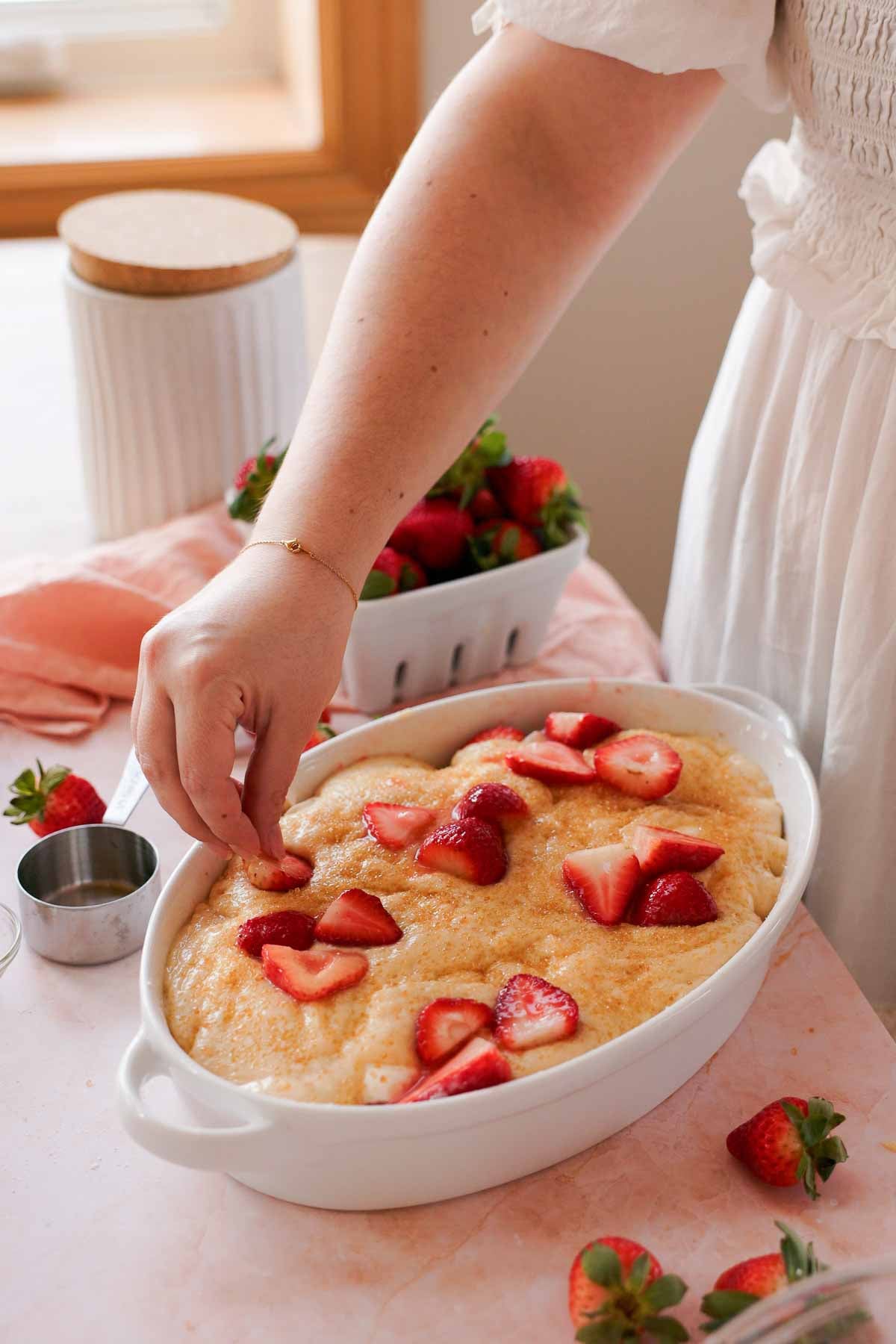 laying strawberries over strawberry cobbler