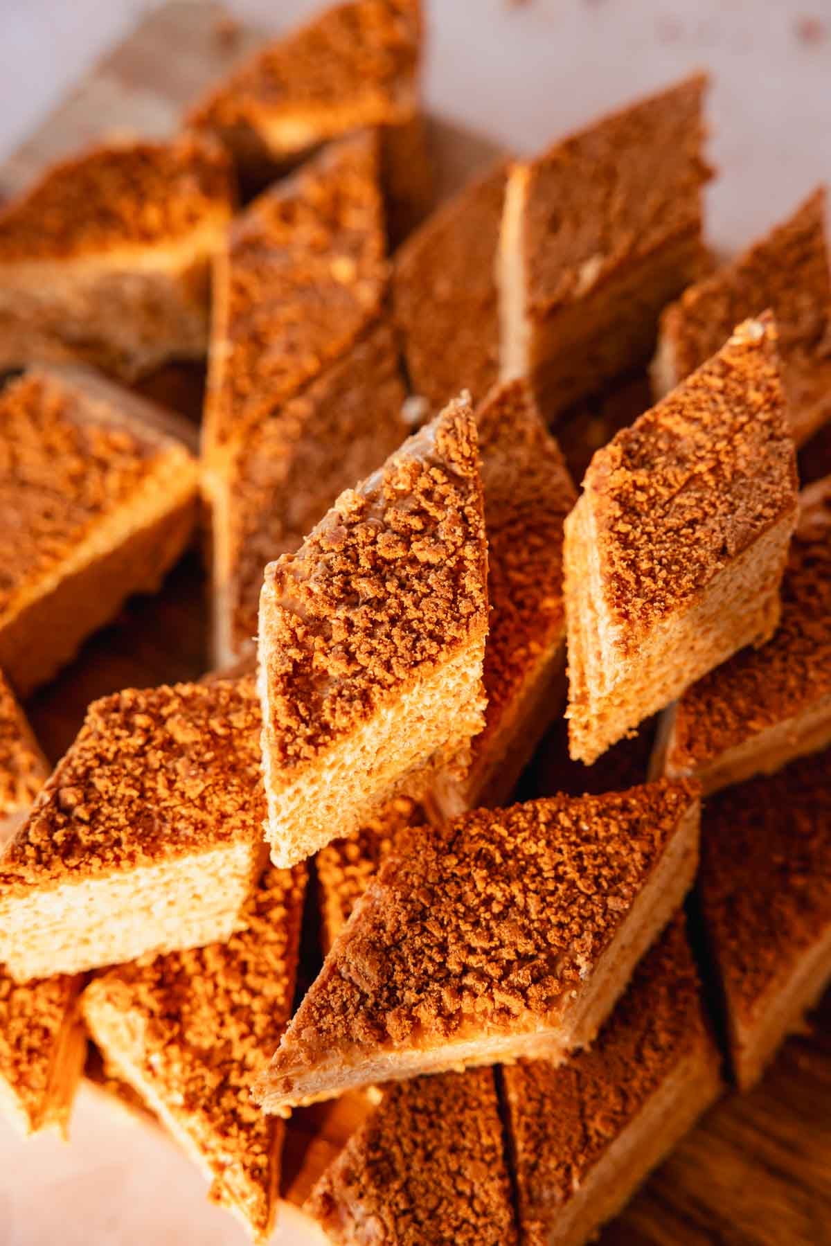 stacked pieces of caramel waffle cake on a cutting board