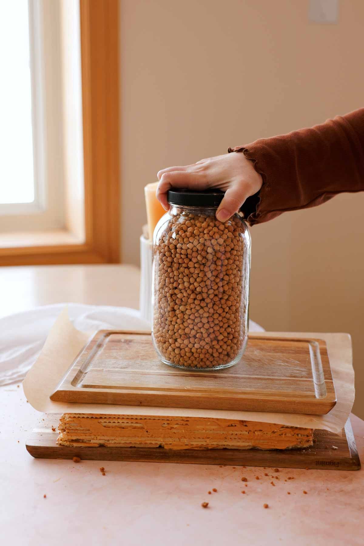 putting jar of chickpeas over dulce de leche cake to weigh it down