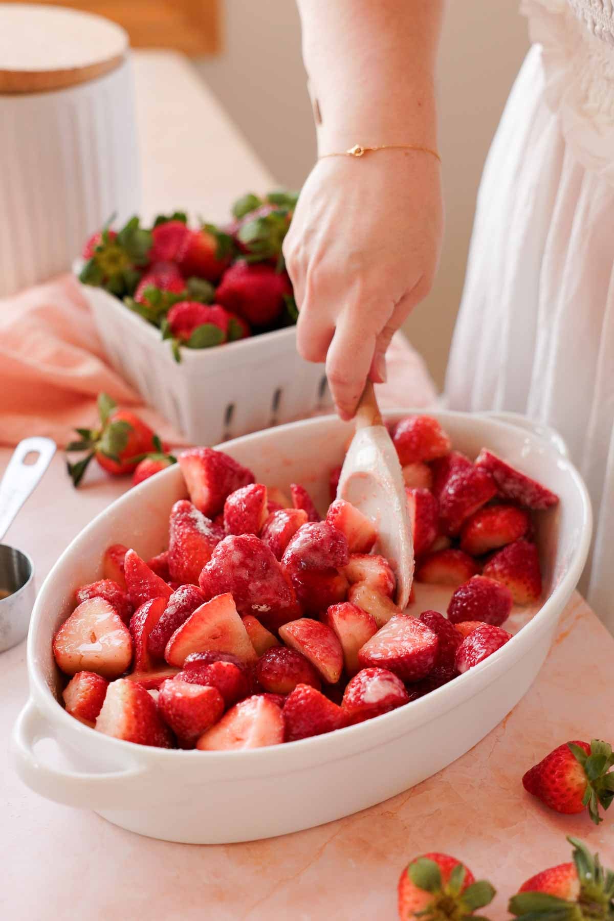 mixing fresh strawberry halves with sugar and cornstarch