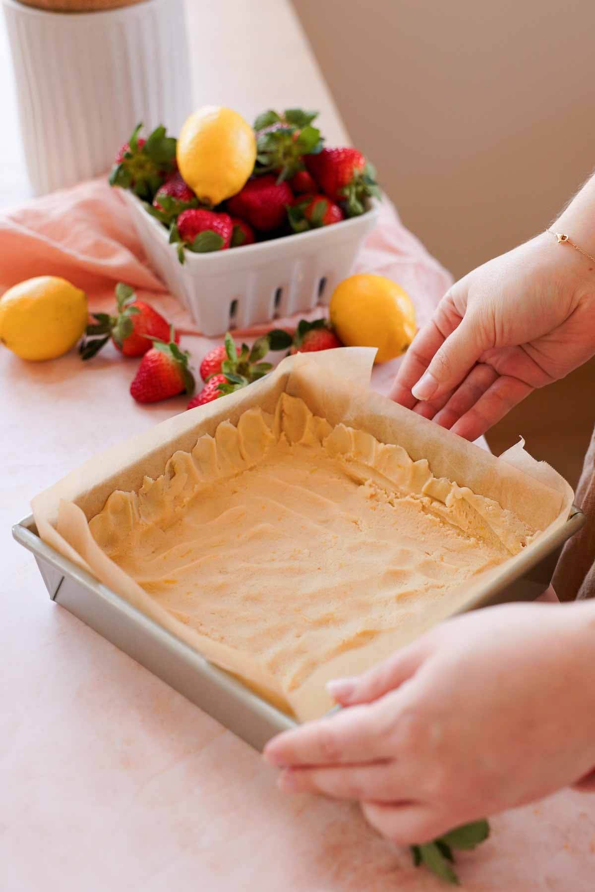 shortbread crust in square pan with crust up along the edges