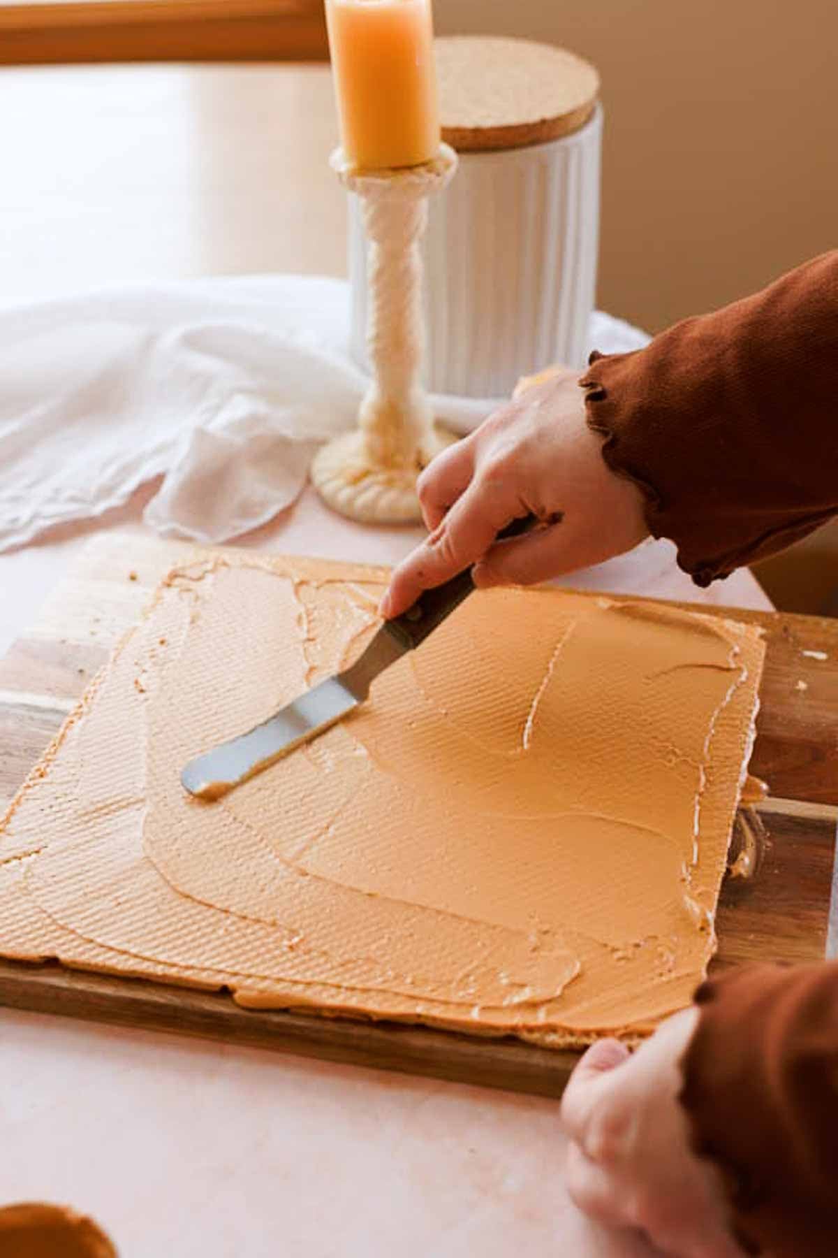 spreading dulce de leche filling between wafer layers