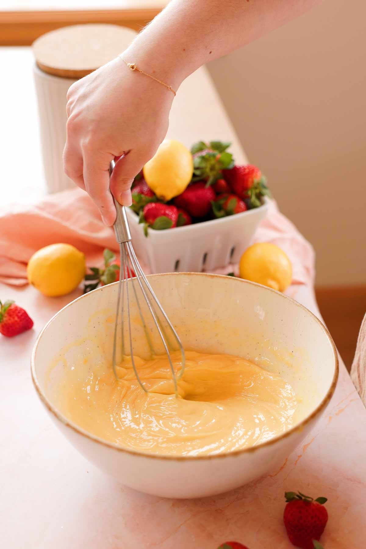 whisking lemon bar filling in a large bowl
