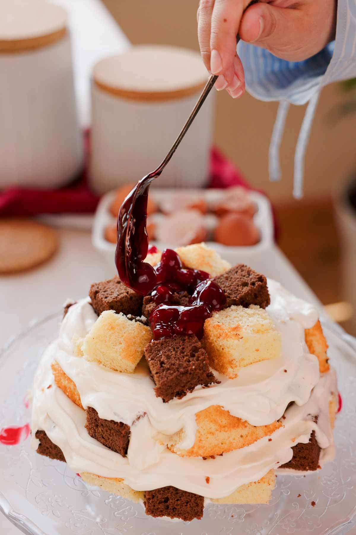 adding cherry pie filling over chunks of vanilla and chocolate cake